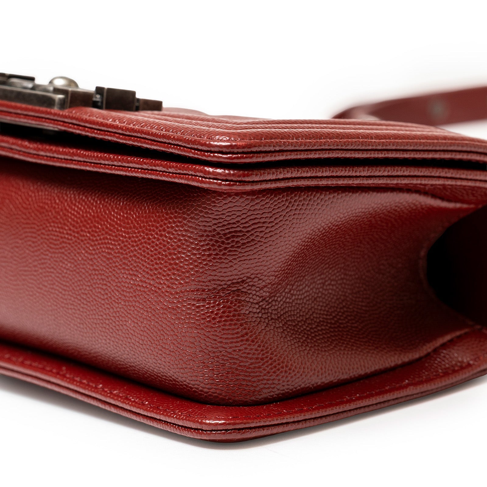 Close-up angled shot of burgundy textured caviar leather on Chanel Small Boy Flap Bag Chevron Burgundy Caviar Palladium Hardware