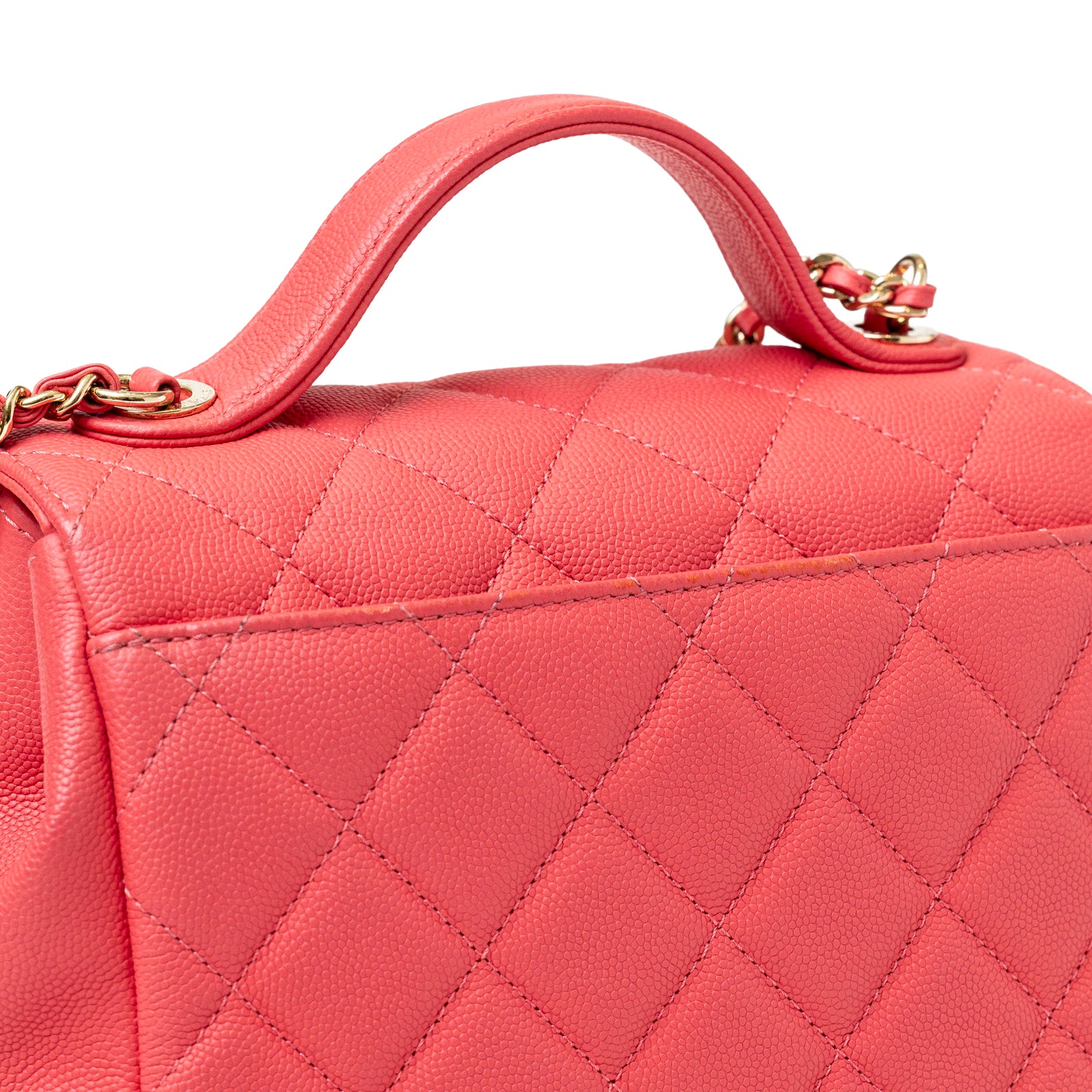 Close-up back of quilted leather texture with handle and chain detail on Chanel Business Affinity Small Flap Bag Pink Caviar Light Gold Hardware