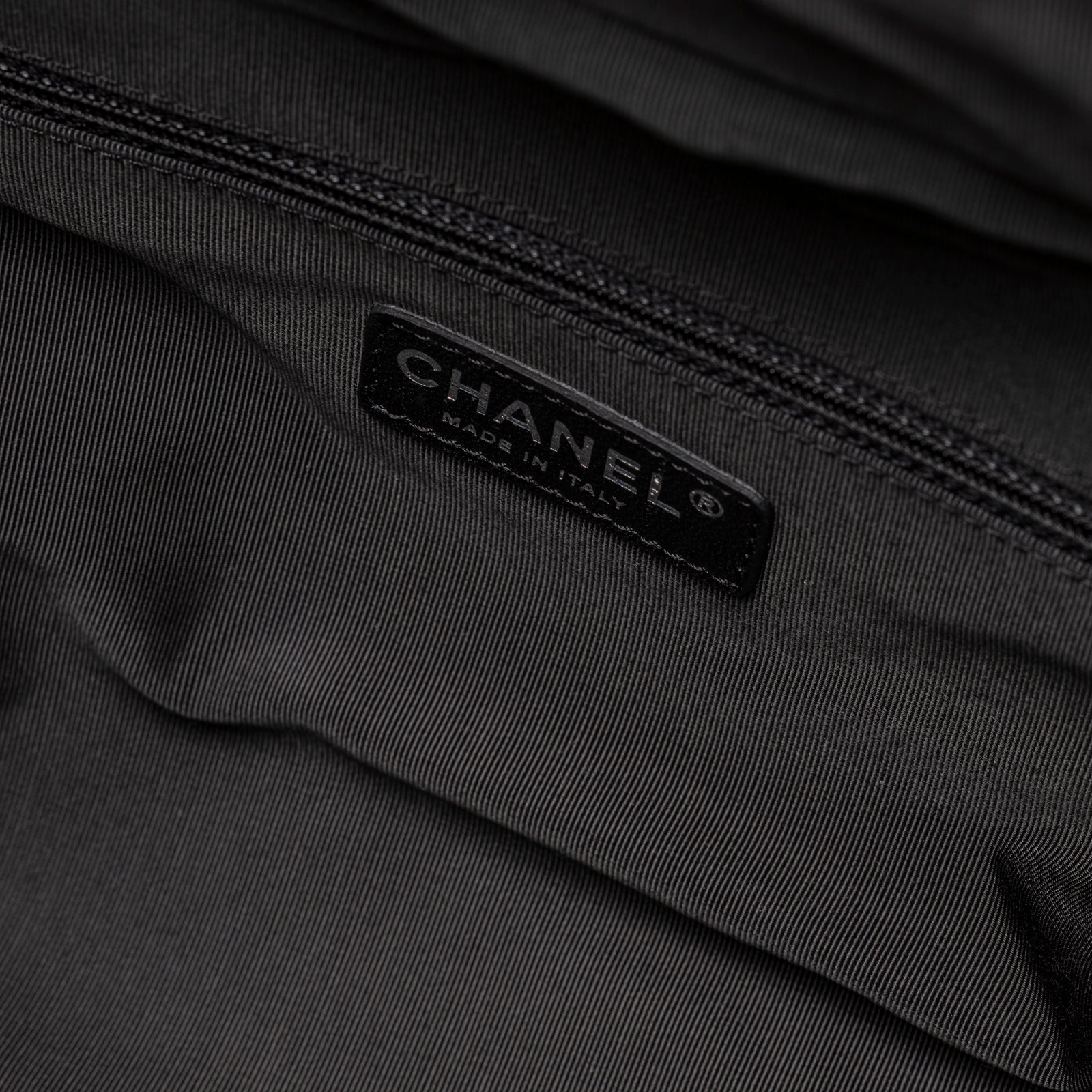 Interior close-up of Chanel CC Quilted Zip Shoulder Bag White & Black Lambskin Palladium Hardware showing logo patch and zipper detail