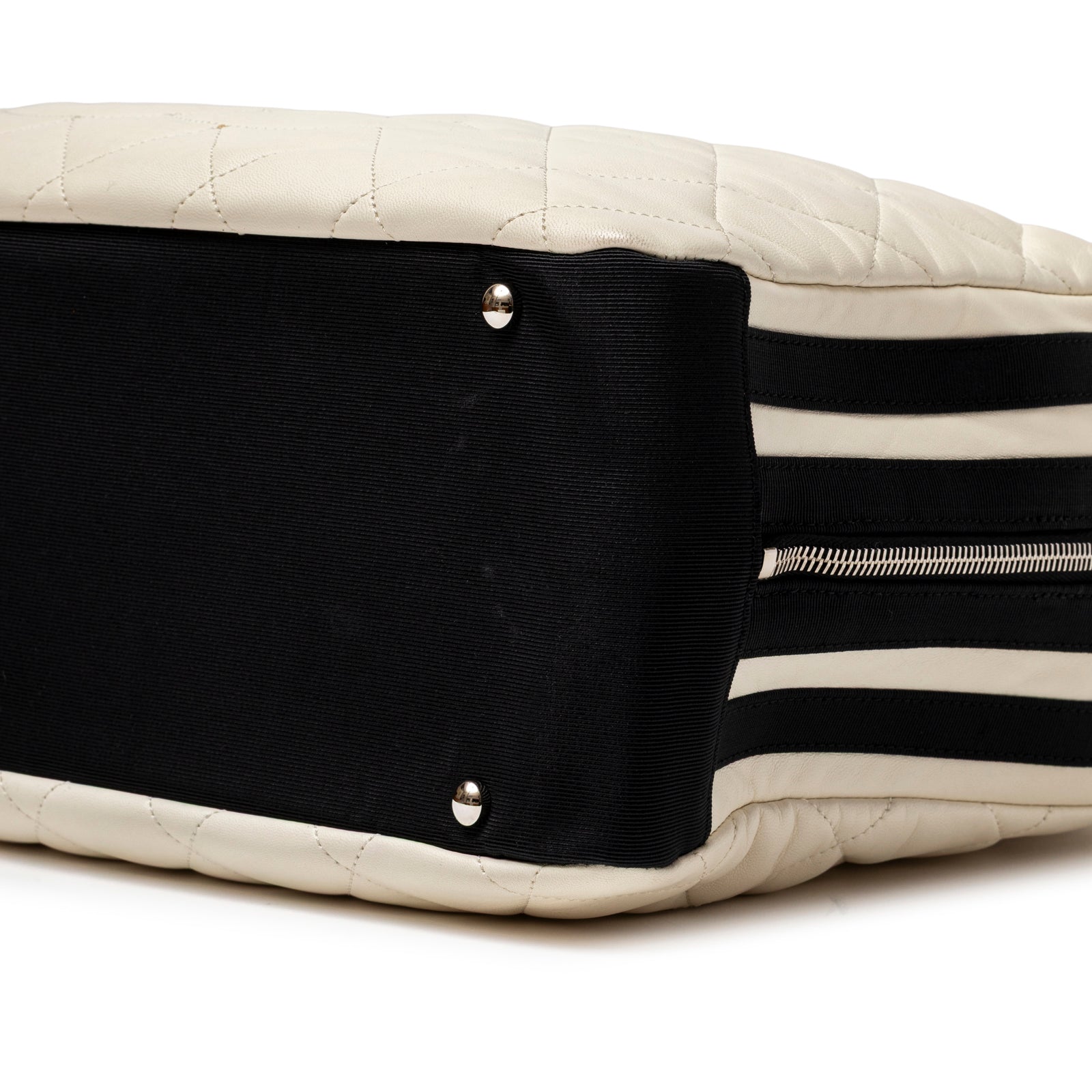 Close-up of bottom corner and striped side panel on Chanel CC Quilted Zip Shoulder Bag White & Black Lambskin Palladium Hardware