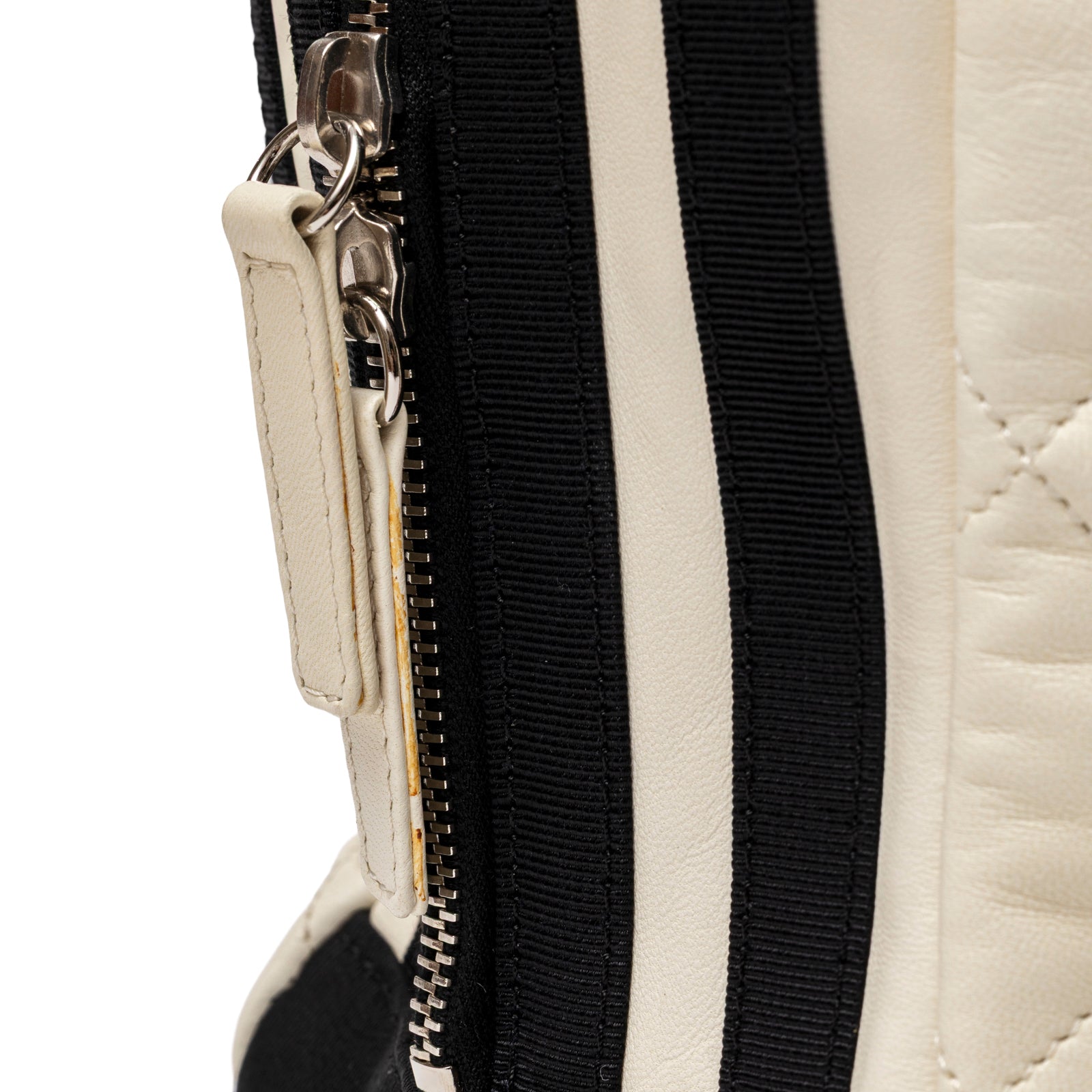 Close-up of zipper and leather pull on Chanel CC Quilted Zip Shoulder Bag White & Black Lambskin Palladium Hardware