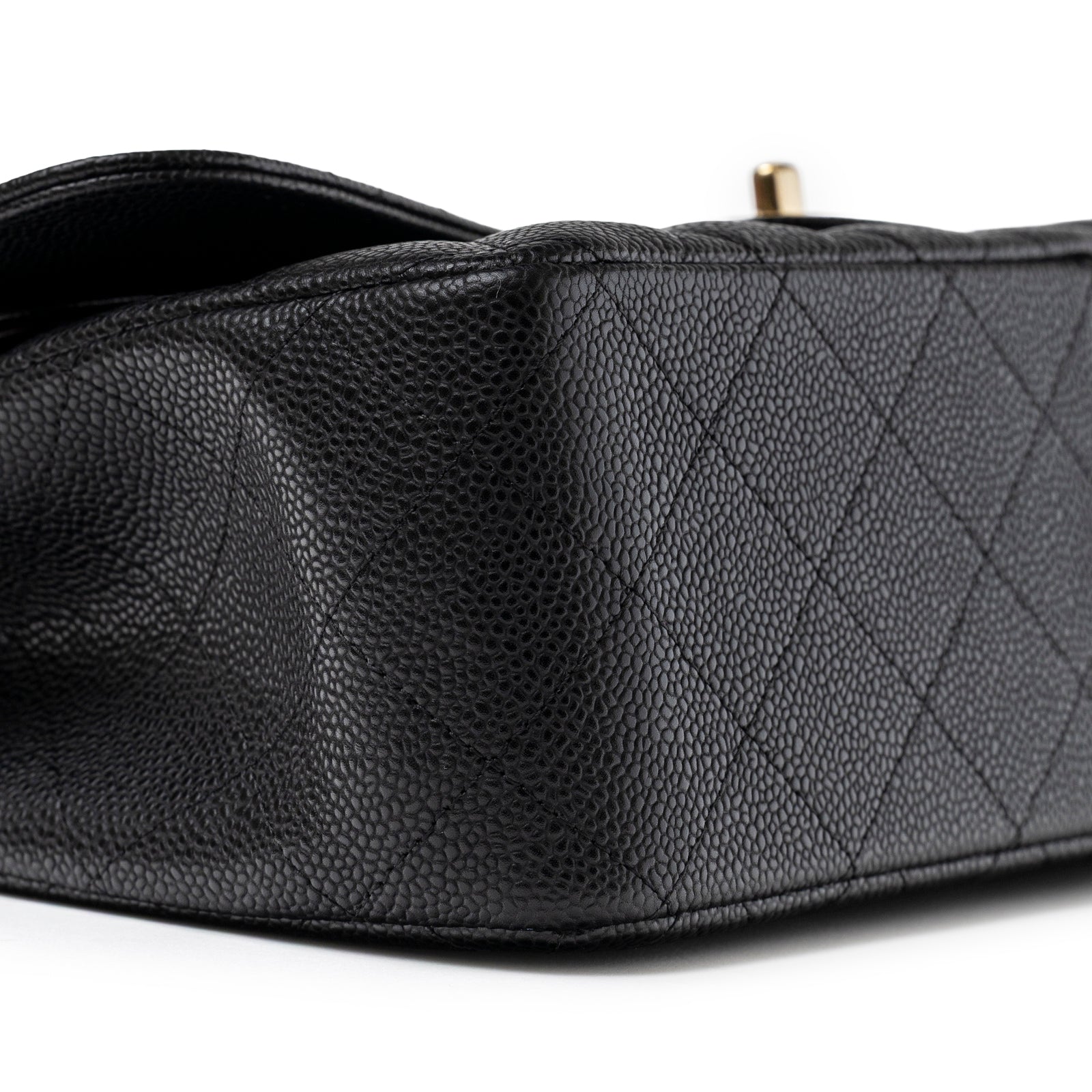Close-up angled view of Chanel Classic Flap Jumbo Caviar Black Gold Hardware showing textured caviar leather and quilted pattern.