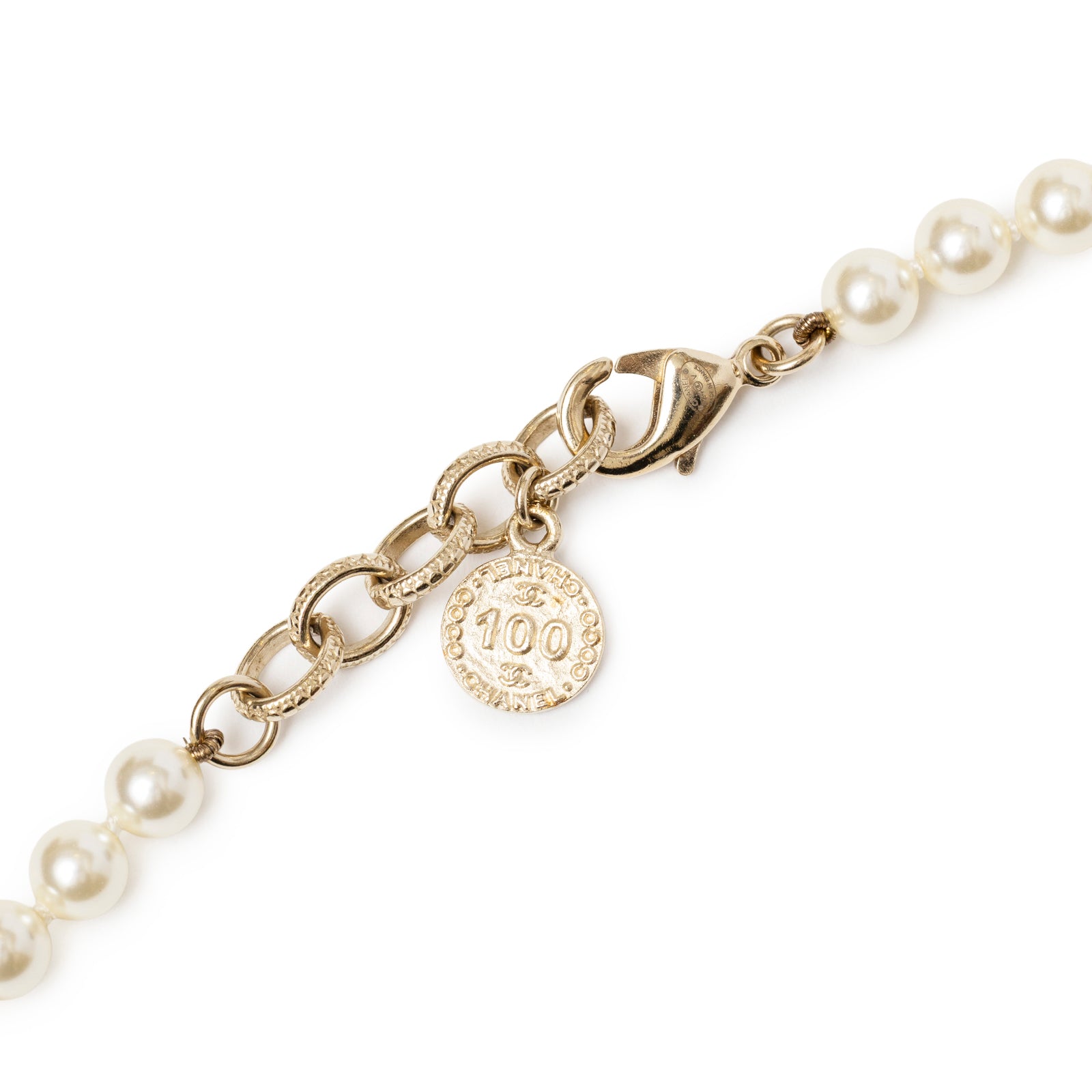 Close-up of gold clasp, chain links, and small round tag on Chanel Graduated Pearl CC Short Necklace Gold