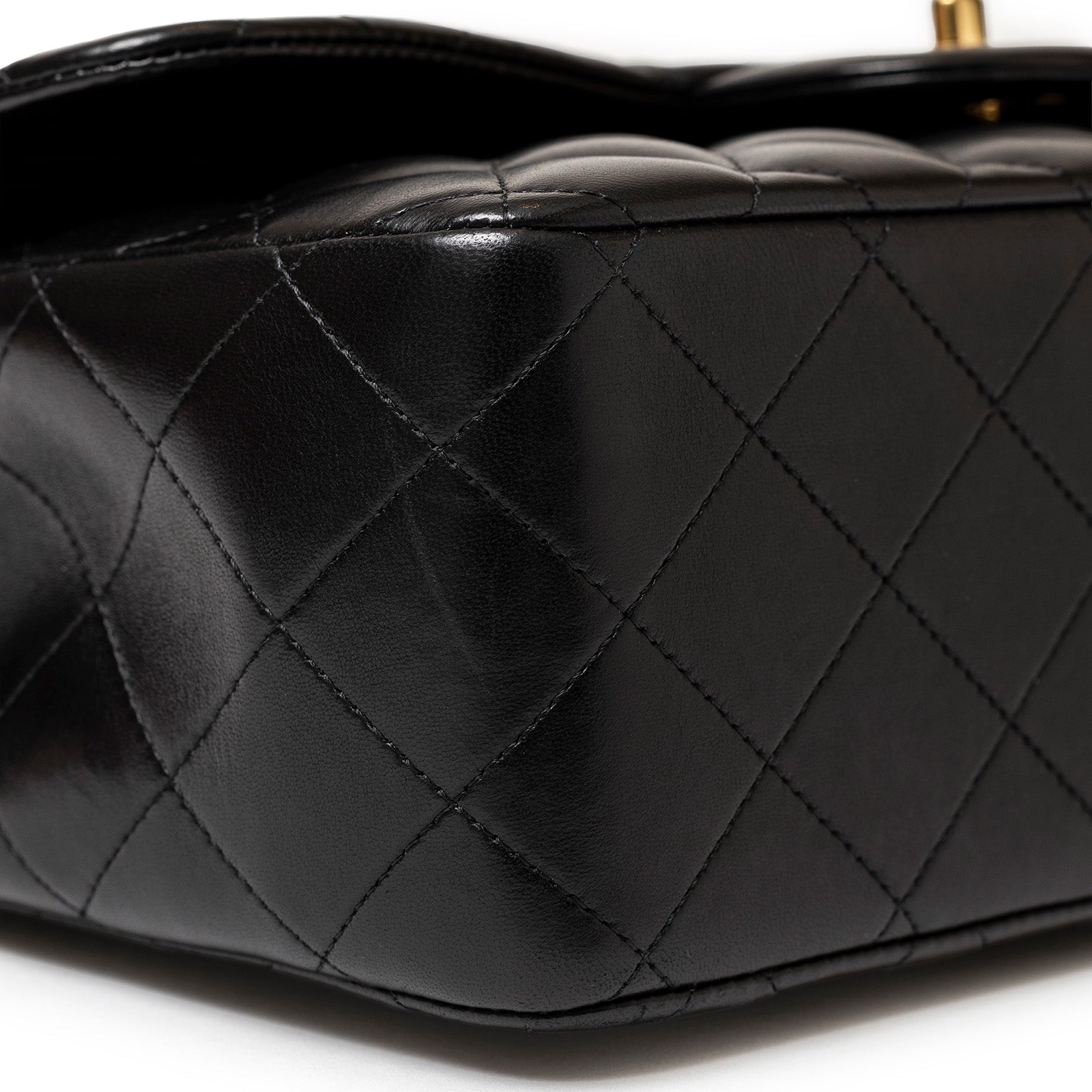 Close-up of black lambskin quilting and stitching on Chanel Jumbo Classic Double Flap Bag Black Lambskin Gold Hardware bottom corner