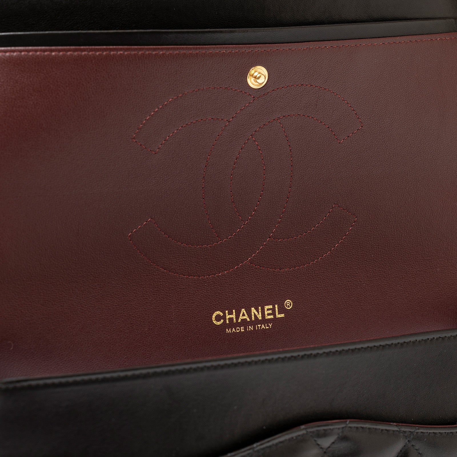 Interior close-up of Chanel Jumbo Classic Double Flap Bag Black Lambskin Gold Hardware showing logo and stitching details