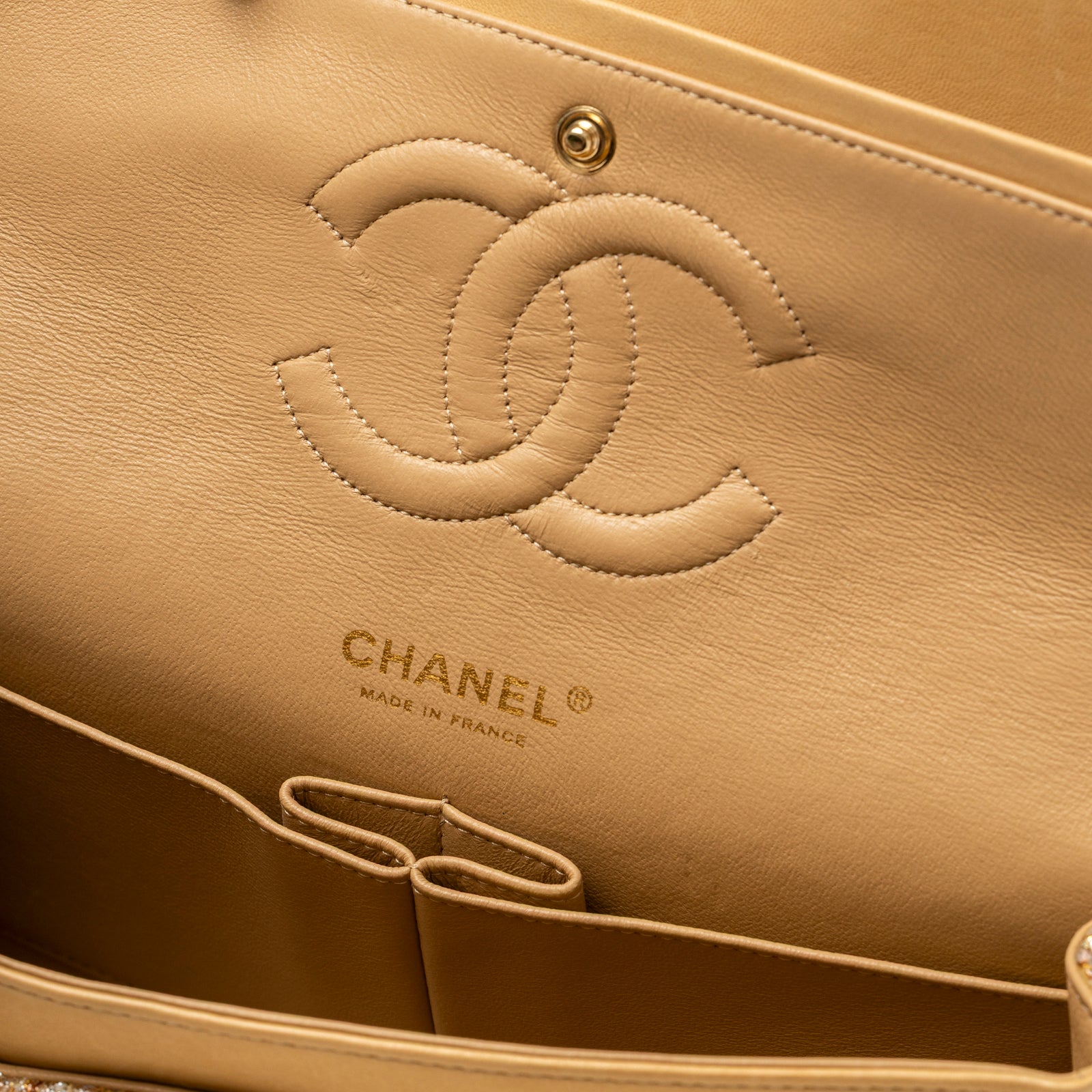 Interior view of Chanel Classic Double Flap Medium Gold Beige Tweed Gold Hardware showing logo emboss and pockets detail