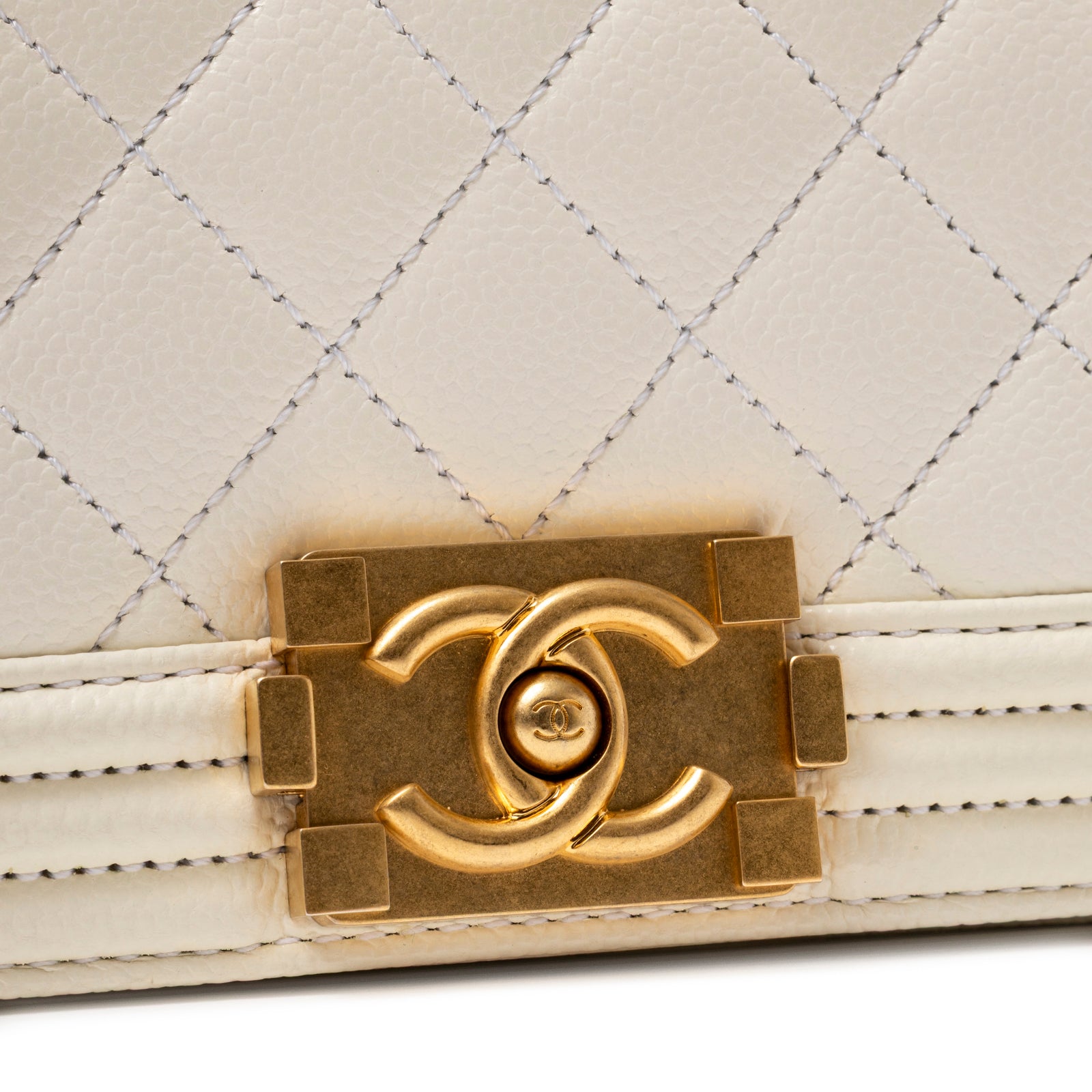 Close-up of gold-tone clasp with interlocking CC logo on Chanel Mini Boy Bag White Caviar Gold Hardware