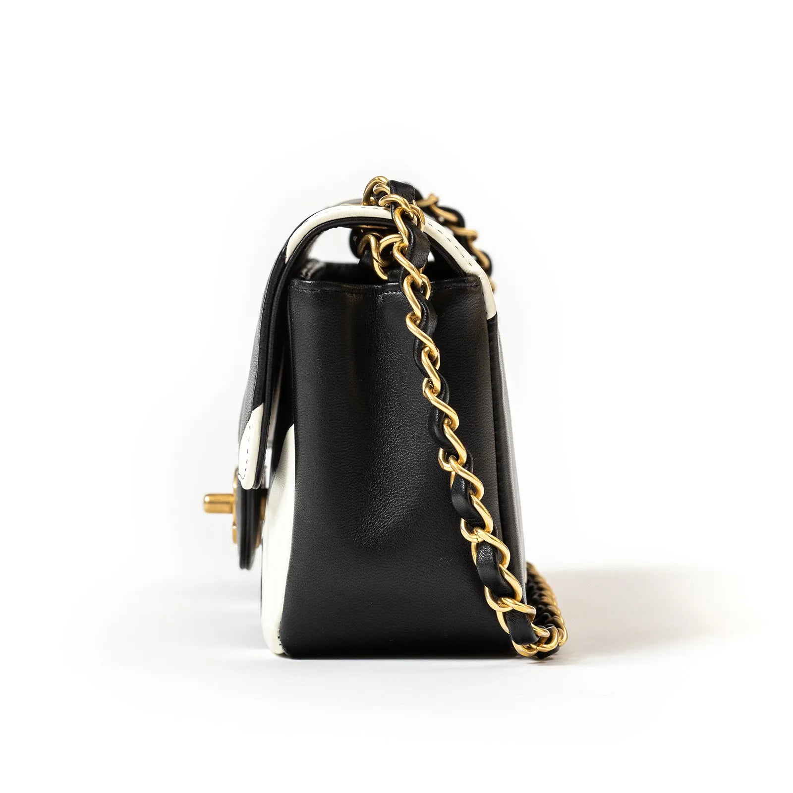 Side view of Chanel Geometric Patchwork Mini Flapbag Gold Hardware with black and white leather and chain strap