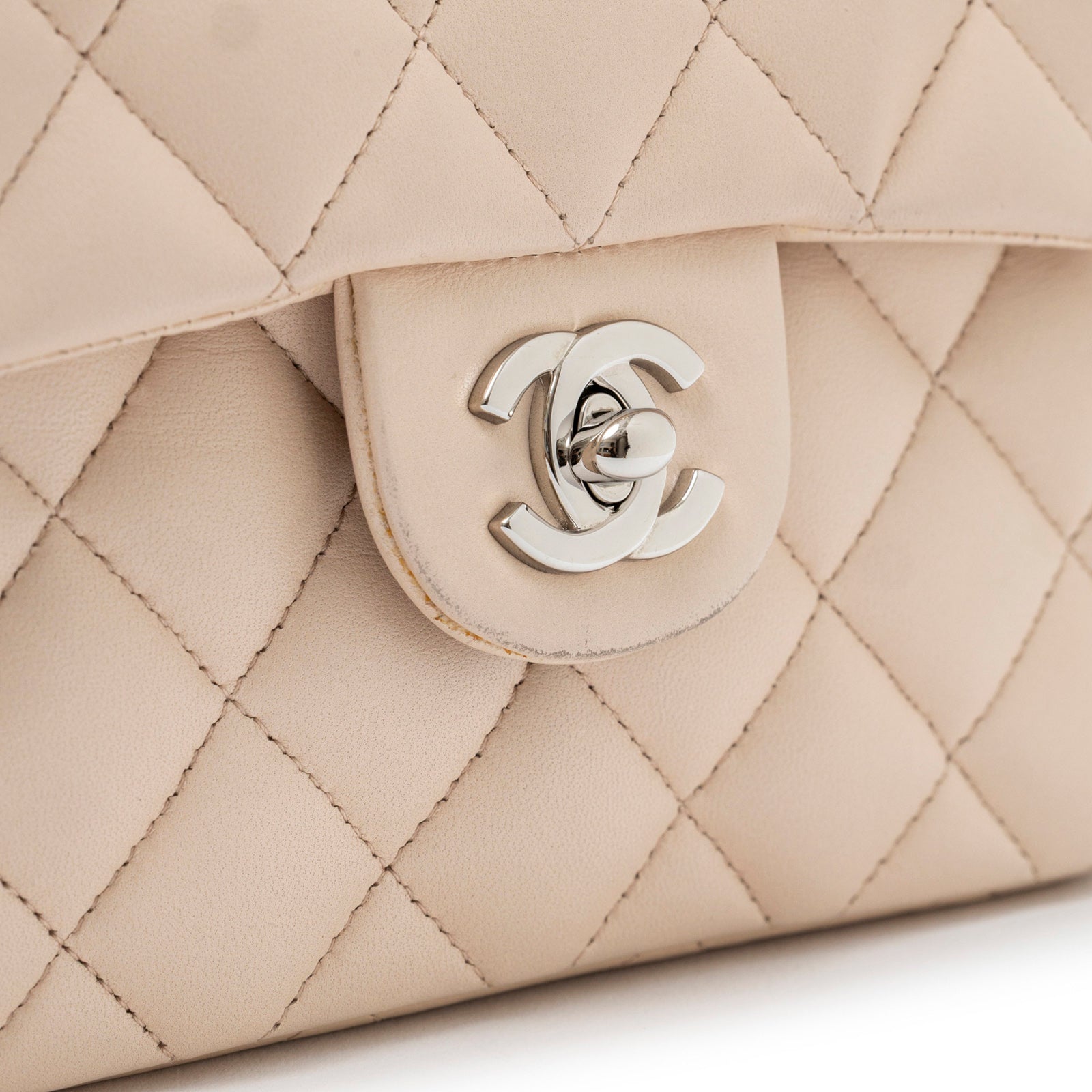 Close-up of the silver hardware twist lock on Chanel Mini Square Single Flap Lambskin Beige Silver Hardware bag