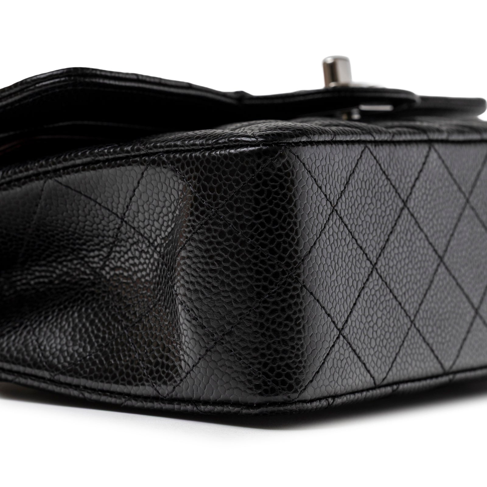 Close-up side view of Chanel Small Classic Flap Bag Black Caviar Palladium Hardware showing textured leather and quilting detail.