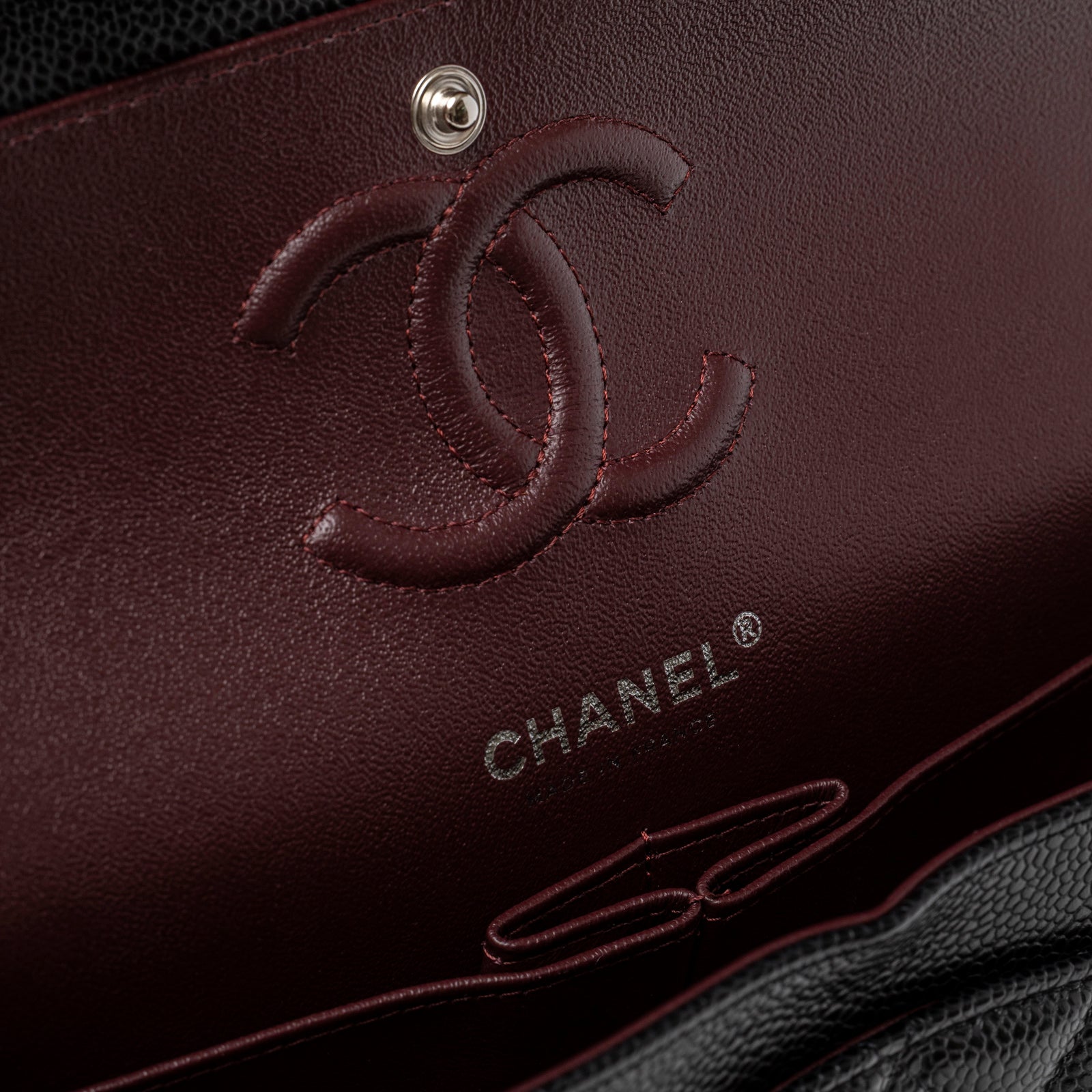 Close-up of the interior flap showing burgundy leather lining and logo of Chanel Small Classic Flap Bag Black Caviar Palladium Hardware