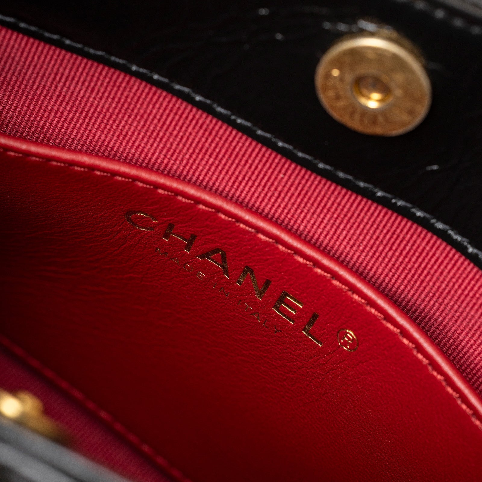 Close-up of interior showing red lining and gold CHANEL logo on Chanel Wavy CC Hobo Small Shiny Quilted Calf Gold Hardware