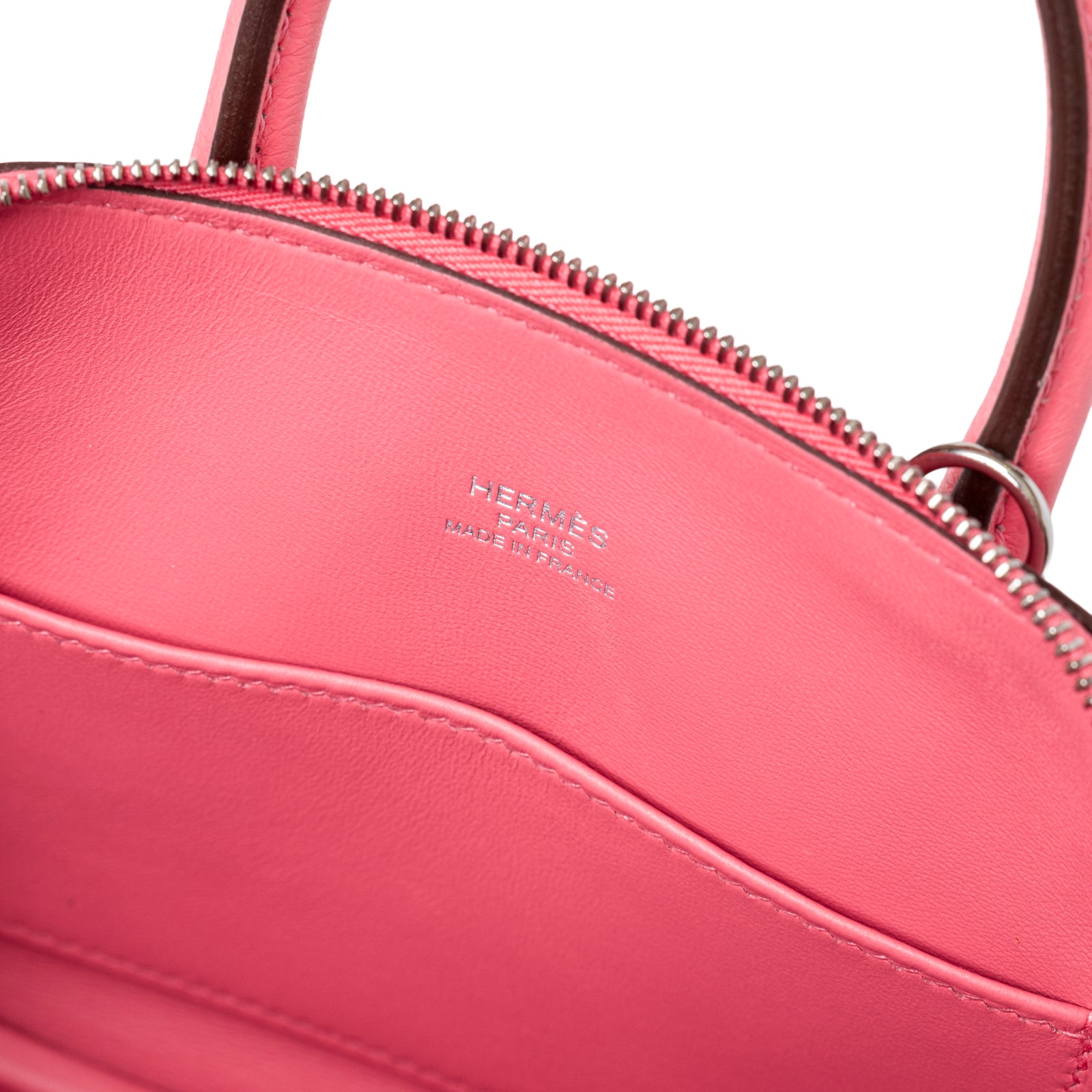 Interior close-up of Hermès 1923 Bolide Mini Rose Azalee Swift Palladium Hardware showing embossed logo and smooth leather pocket