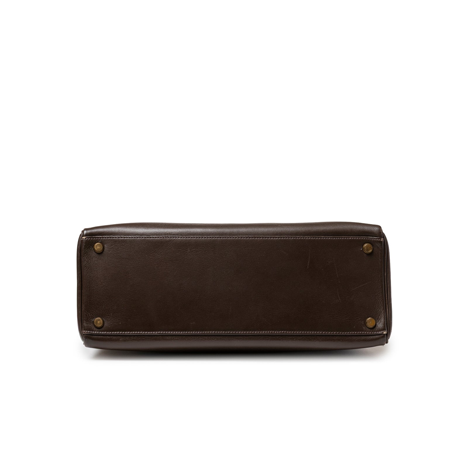 Bottom close-up of Hermès 1974 Vintage Kelly 32 Marron Foncé Box Gold Hardware showing leather base and gold studs