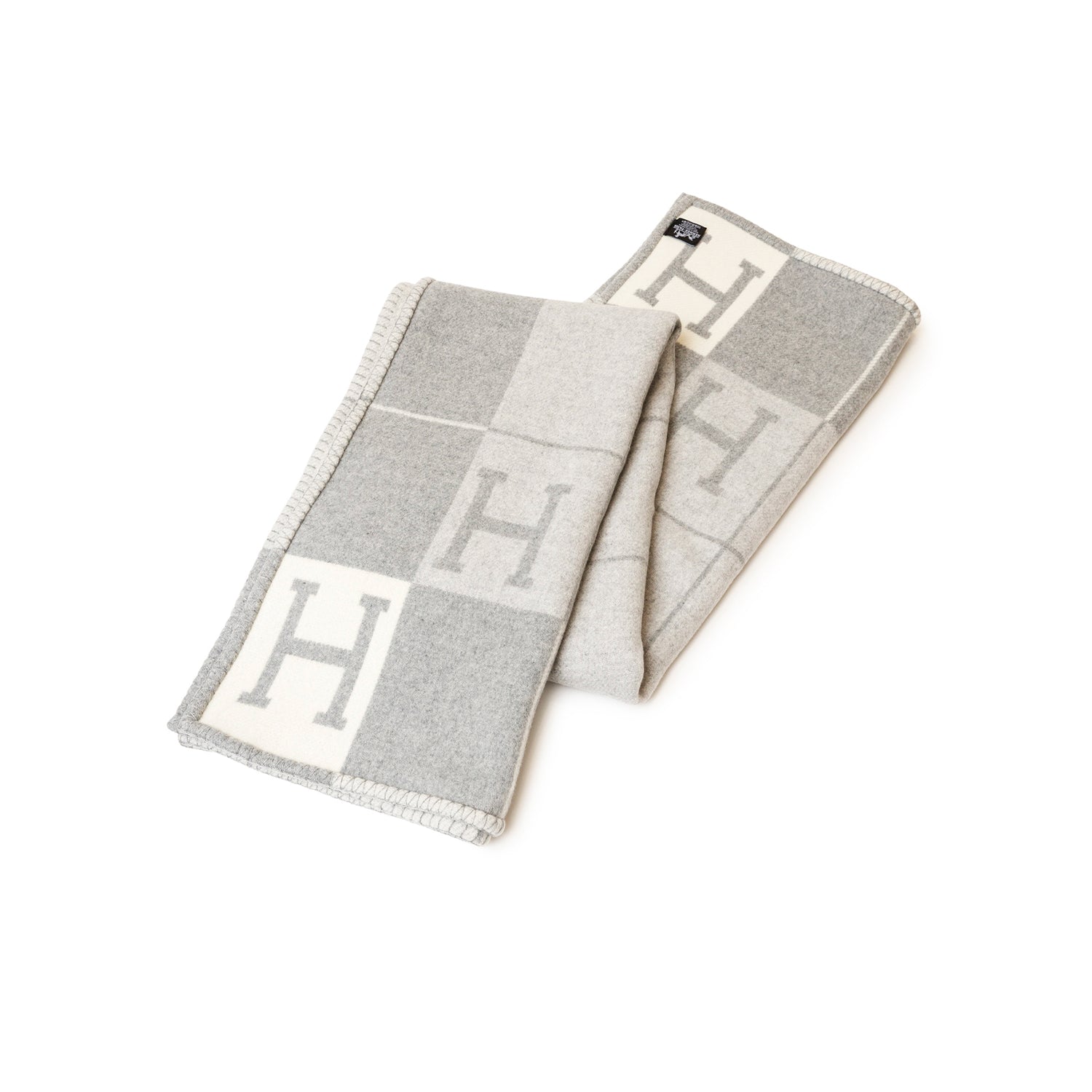 Hermès Avalon Throw Blanket Ecru Gris Clair folded, showcasing soft, neutral tones and elegant H pattern design.