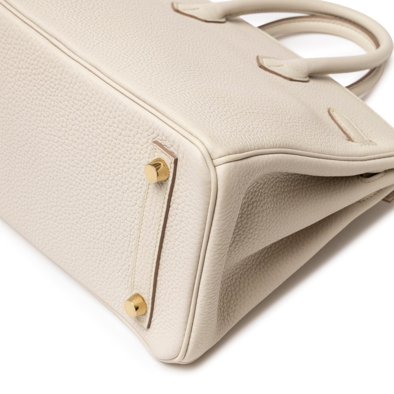 Close-up of base corner on Hermès Birkin 25 Beton Togo Gold Hardware with textured leather and gold studs