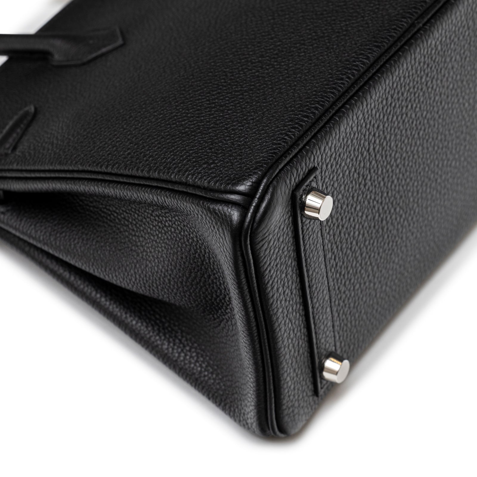 Close-up of textured black leather corner and polished palladium hardware feet on Hermès Birkin 25 Black Togo Palladium Hardware