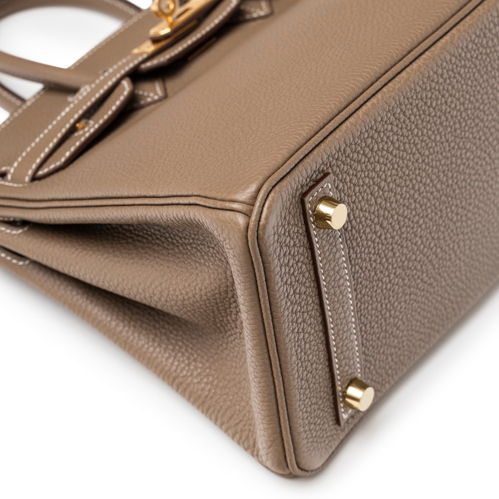 Close-up of bottom corner and gold feet on Hermès Birkin 25 Etoupe Togo Gold Hardware textured leather bag
