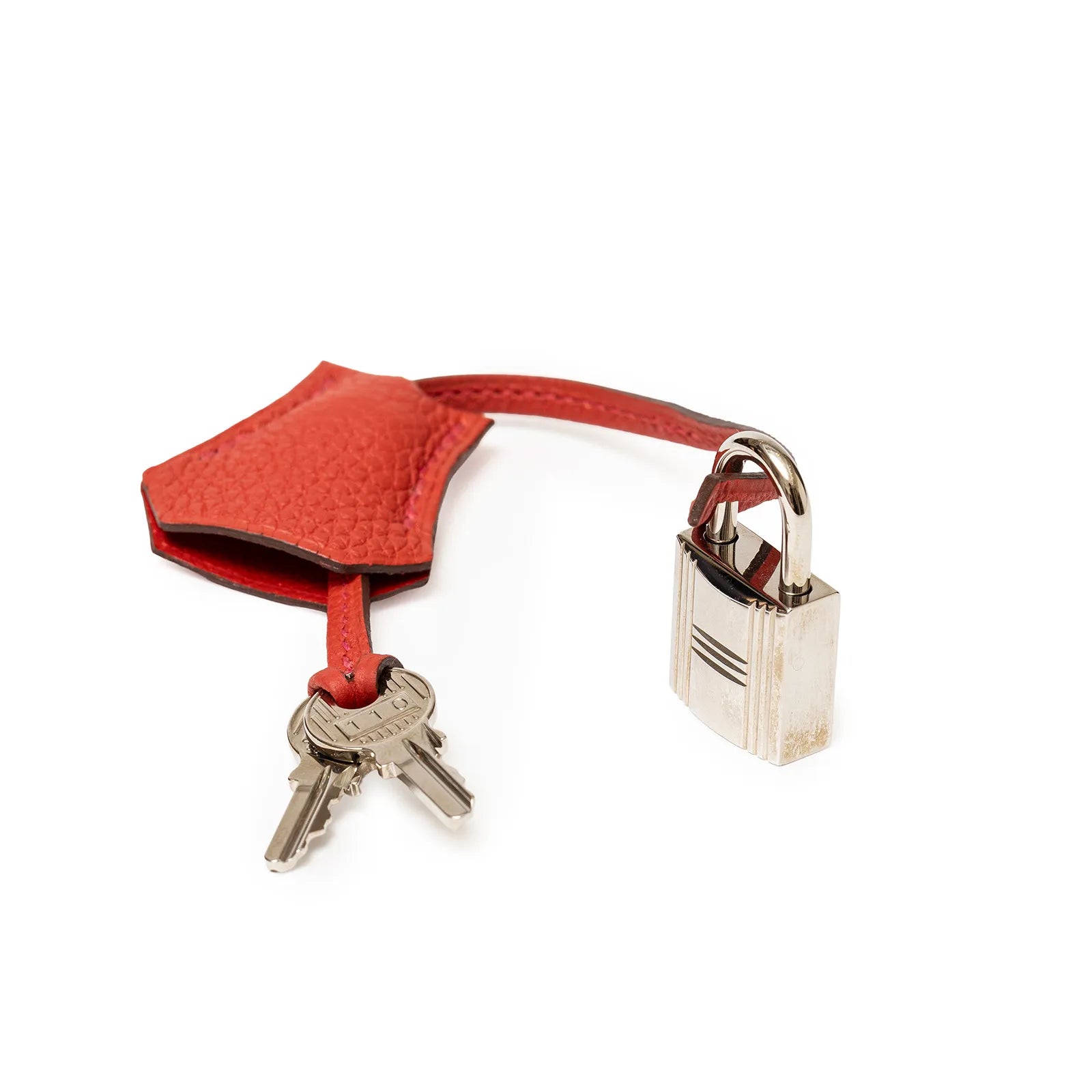 Close-up of Hermès Birkin 25 Geranium Togo palladium hardware lock, keys, and leather clochette accessory.