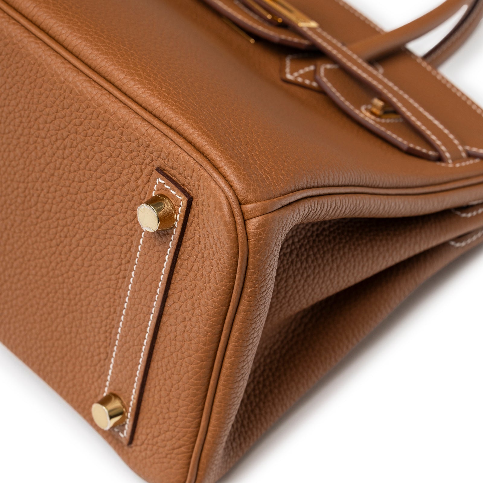 Close-up of bottom corner and gold feet on Hermès Birkin 25 Gold Togo Gold Hardware handbag in soft leather