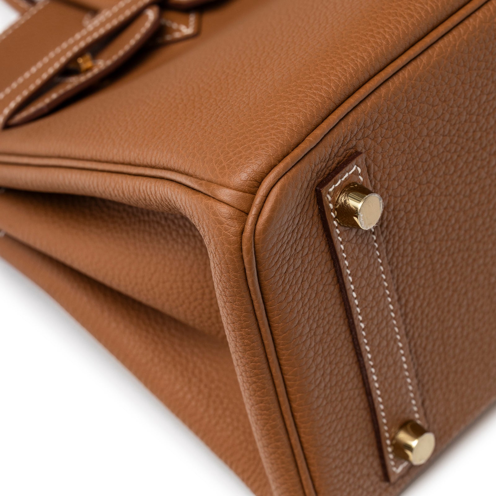 Close-up view of Hermès Birkin 25 Gold Togo Gold Hardware bottom corner with gold feet and stitching detail