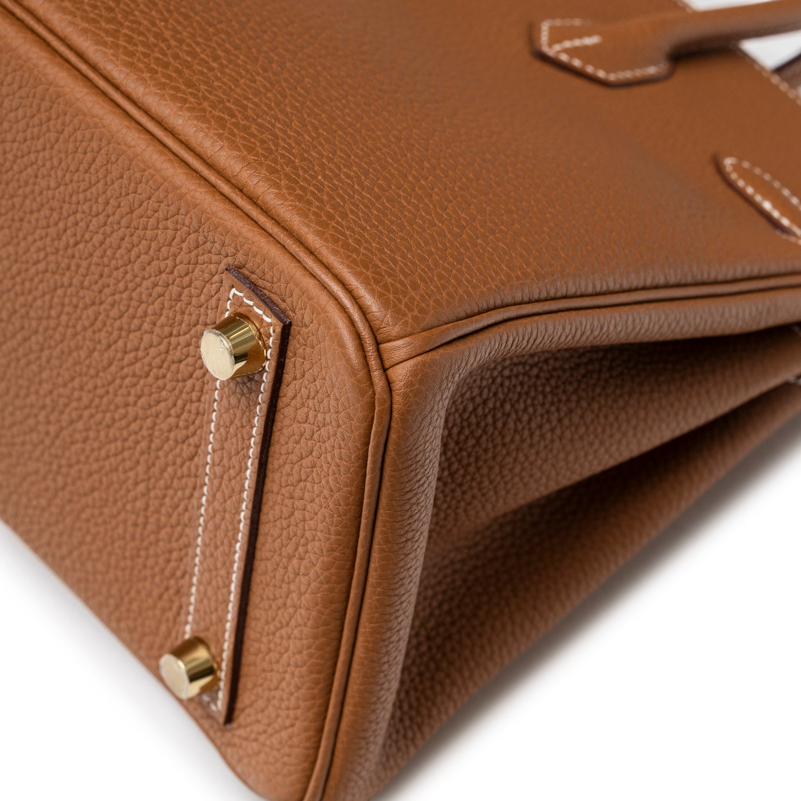 Close-up of base corner showing Hermès Birkin 25 Gold Togo Gold Hardware stitching and gold feet details