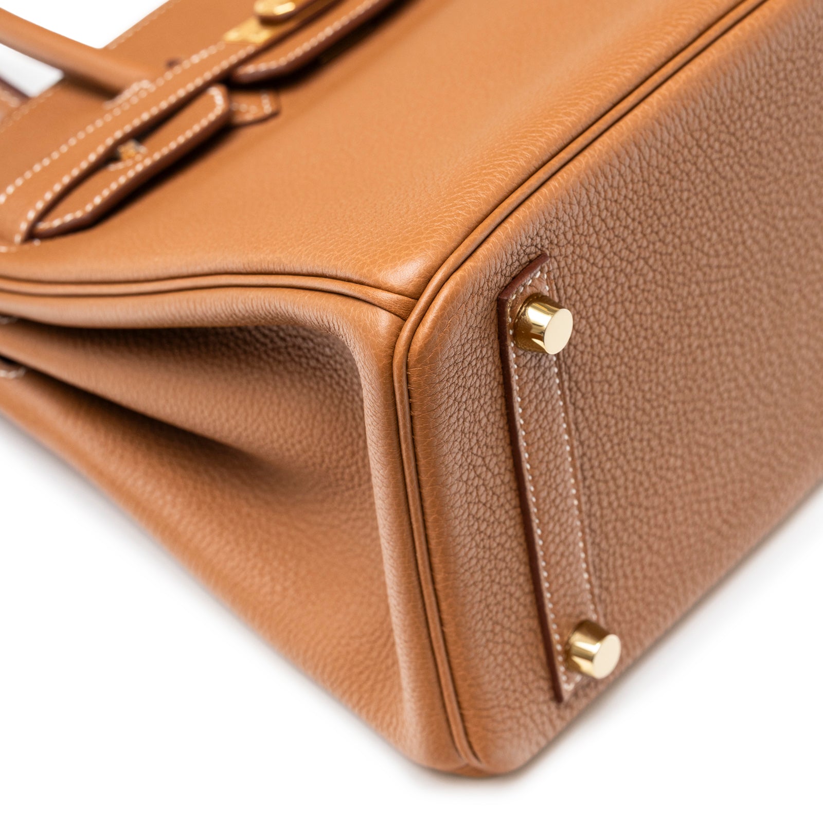 Close-up angled shot of the Hermès Birkin 25 Gold Togo Gold Hardware corner and textured leather grain.