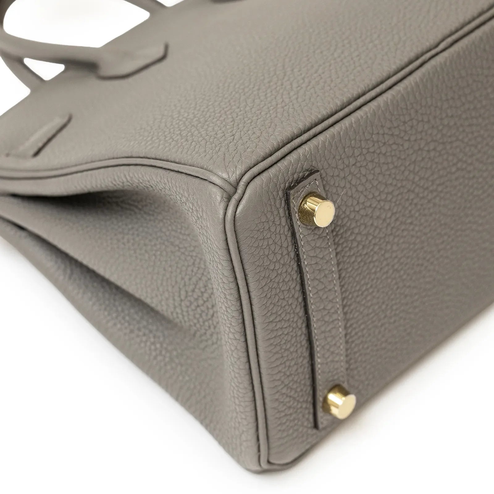 Close-up angled view of Hermès Birkin 25 Gris Meyer Togo leather showing gold feet and textured grain detail