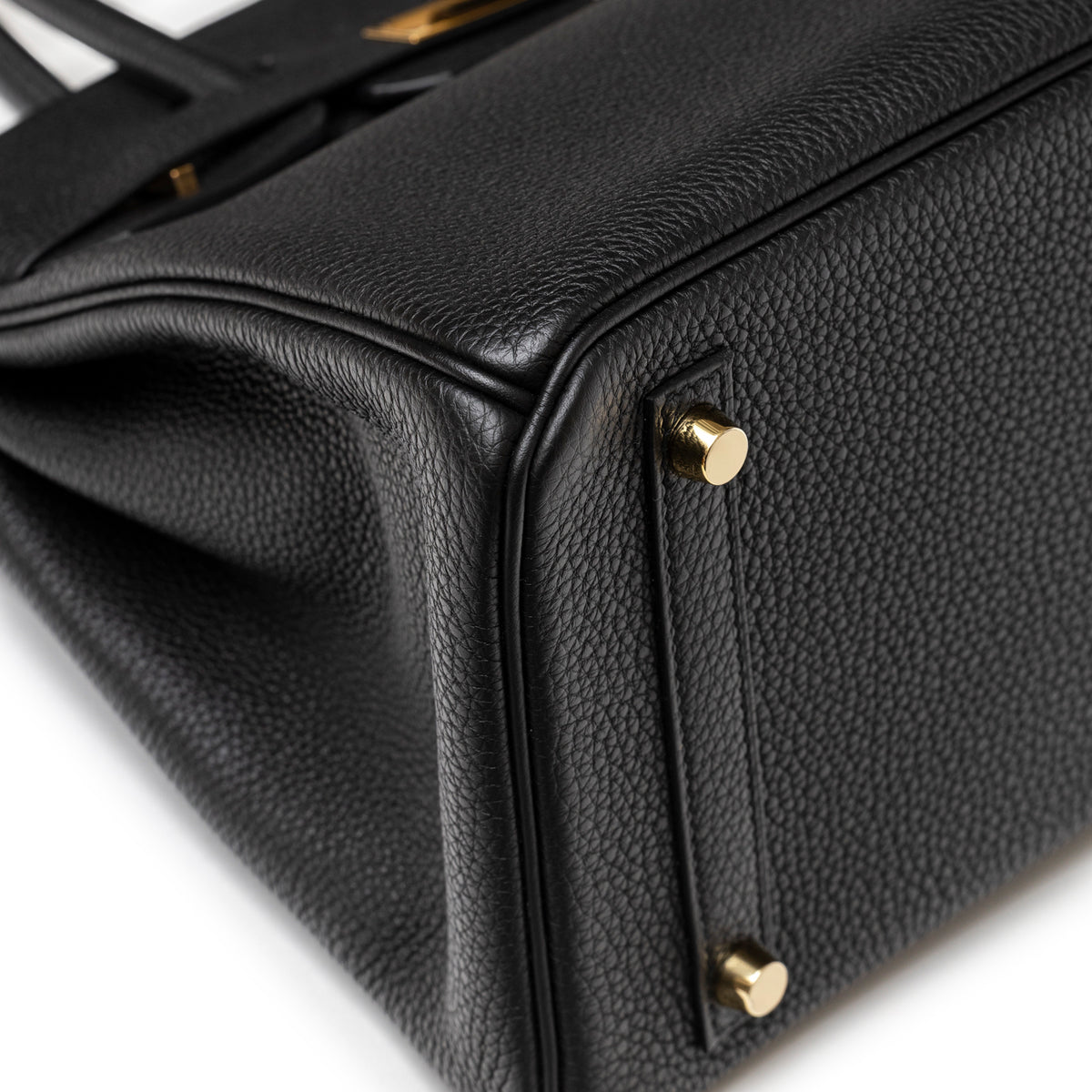 Close-up of base corner on Hermès Birkin 30 Black Togo Gold Hardware showing pebbled leather and gold feet detail