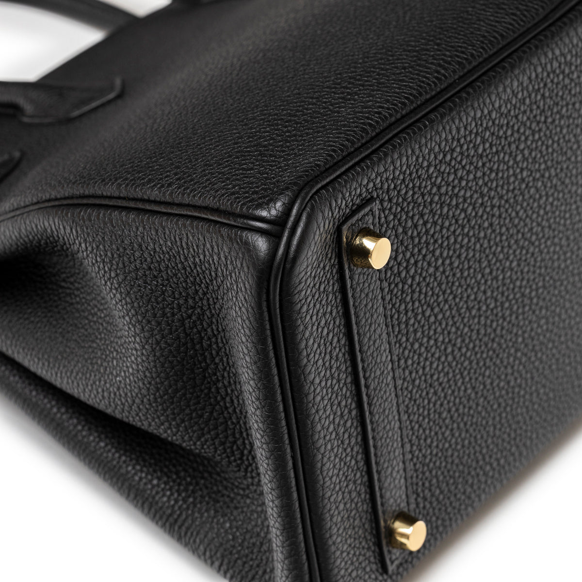 Close-up of Hermès Birkin 30 Black Togo Gold Hardware base corner showing textured leather and gold feet detail
