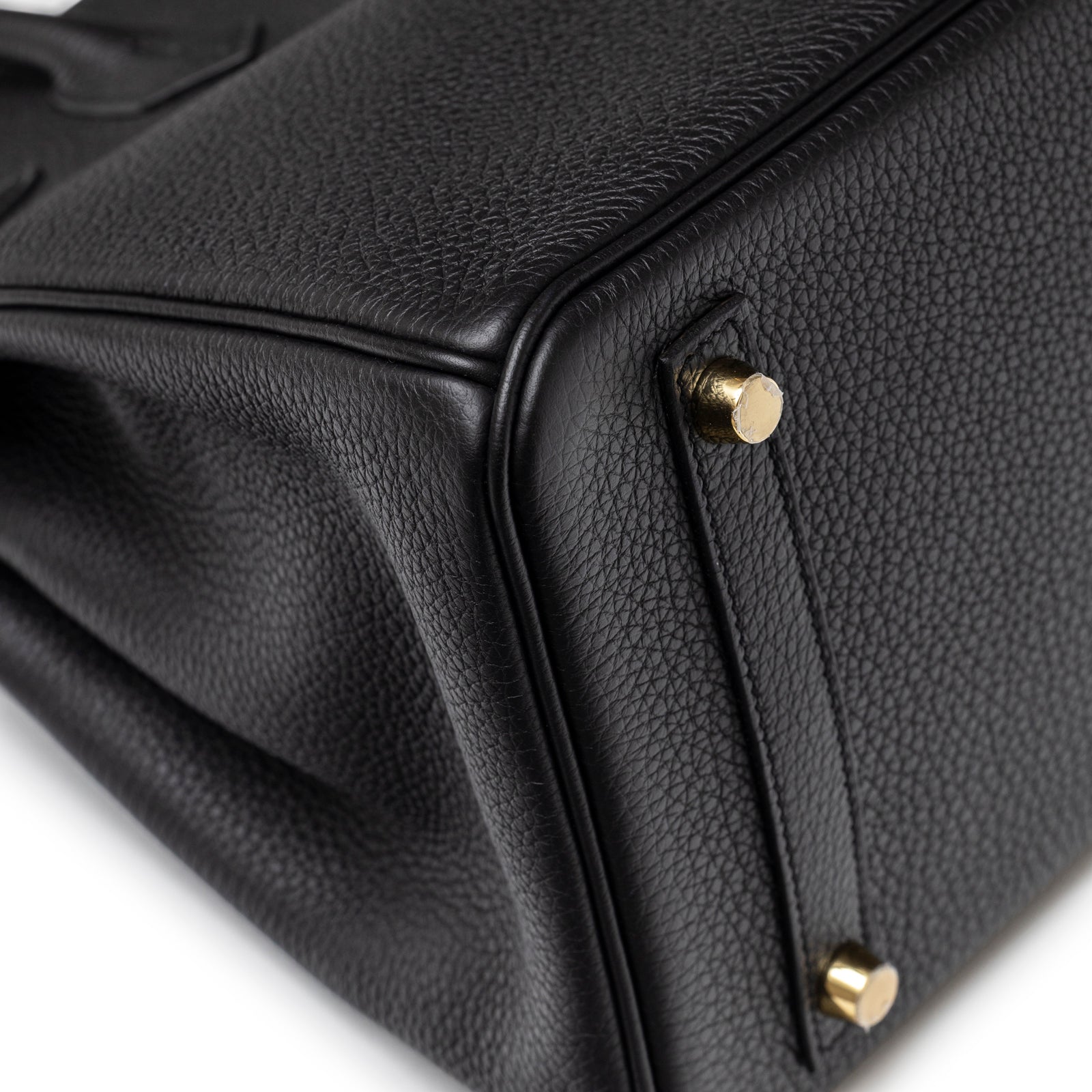 Close-up of bottom corner and gold feet on Hermès Birkin 30 Black Togo Gold Hardware handbag textured leather