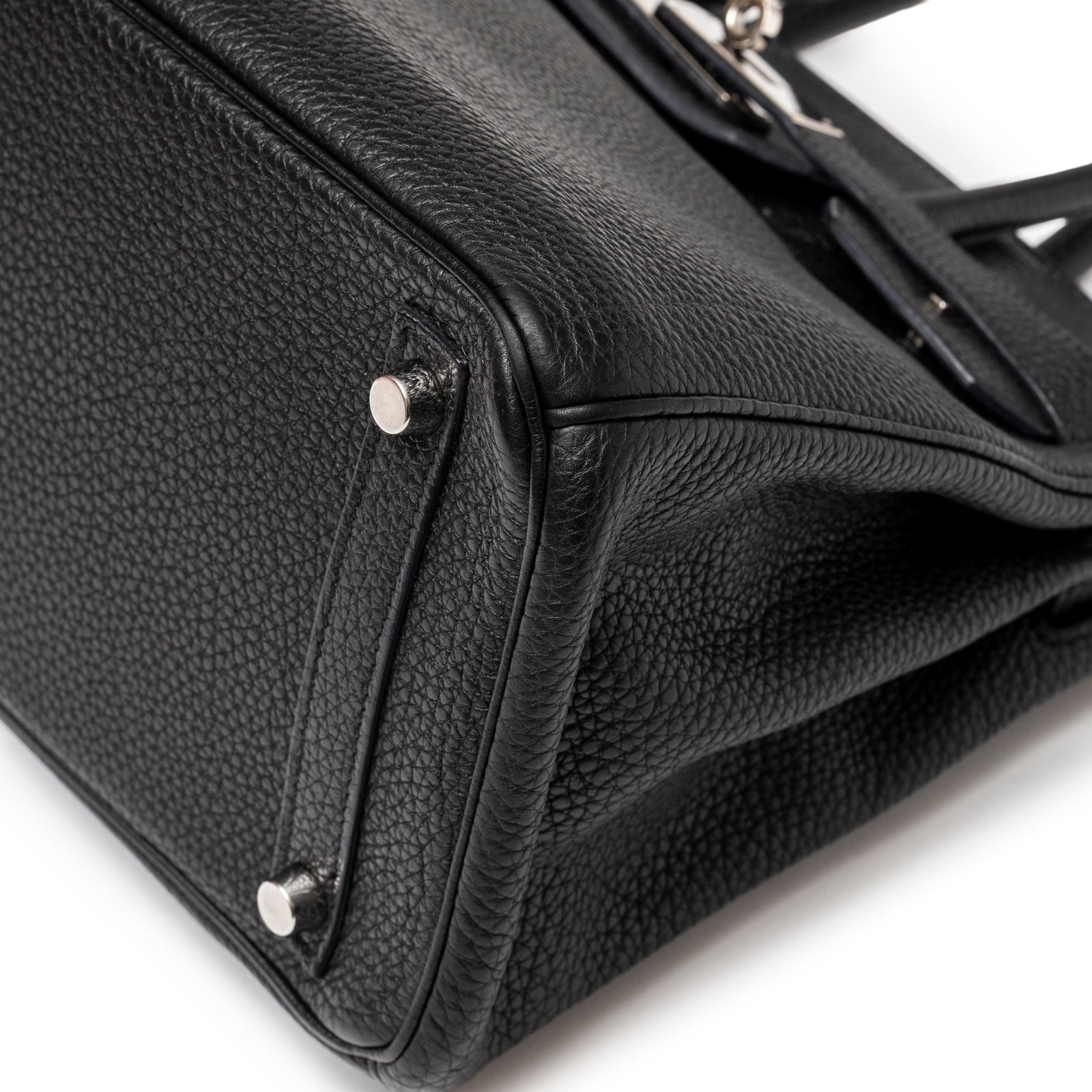 Close-up of Hermès Birkin 30 Black Togo Palladium Hardware showing textured leather and metal feet detail.