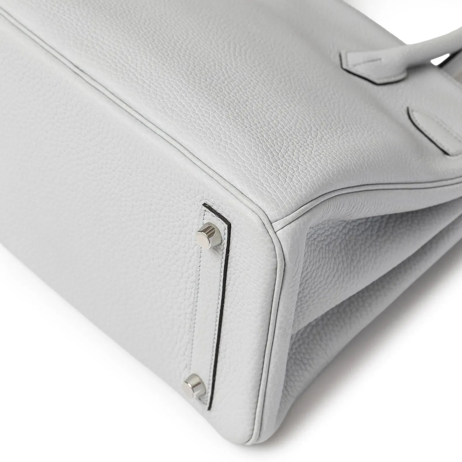Close-up of the Hermès Birkin 30 bottom corner showing bleu pale Clemence leather and palladium hardware feet.