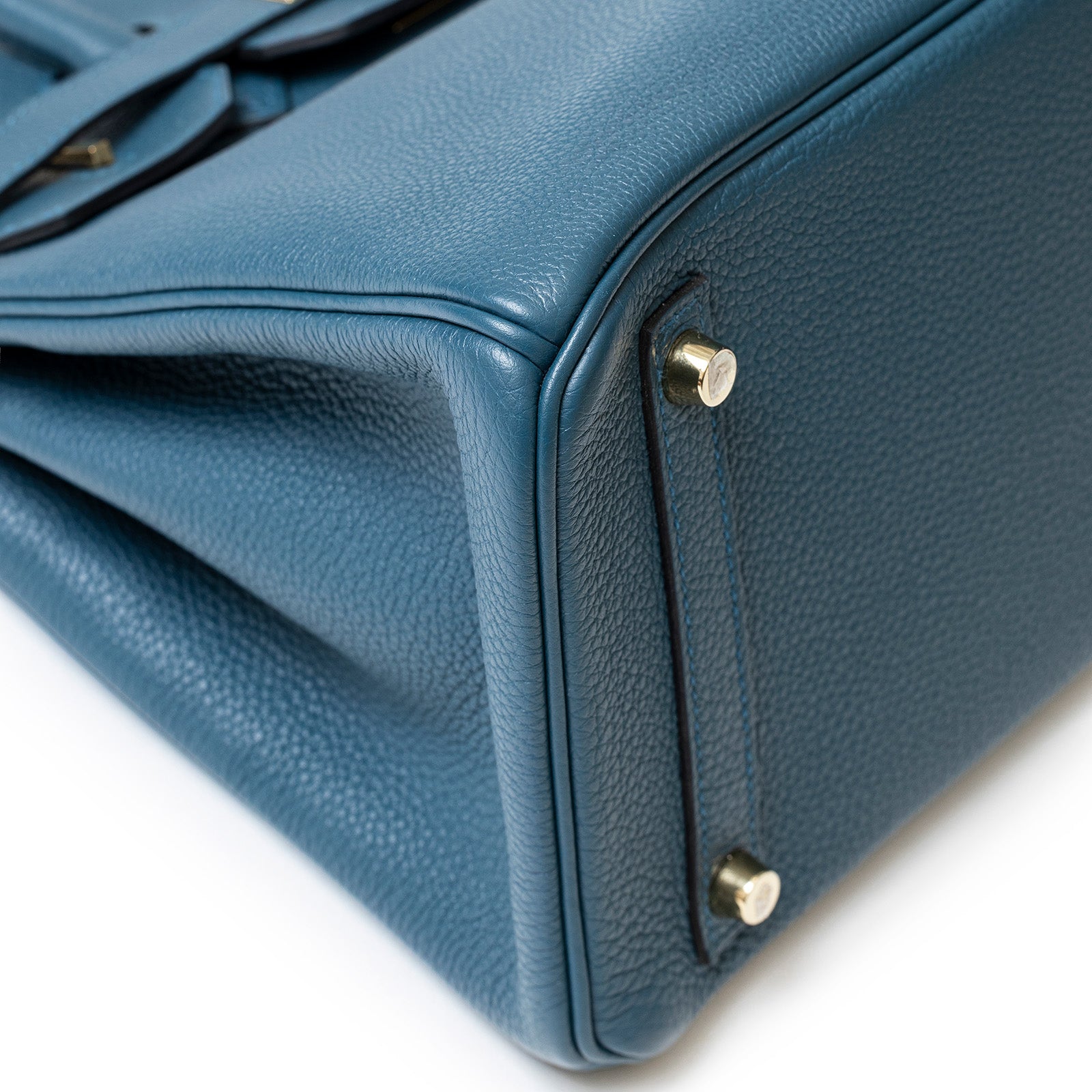 Close-up bottom corner view of Hermès Birkin 30 Colvert Togo Gold Hardware showing leather texture and gold feet.