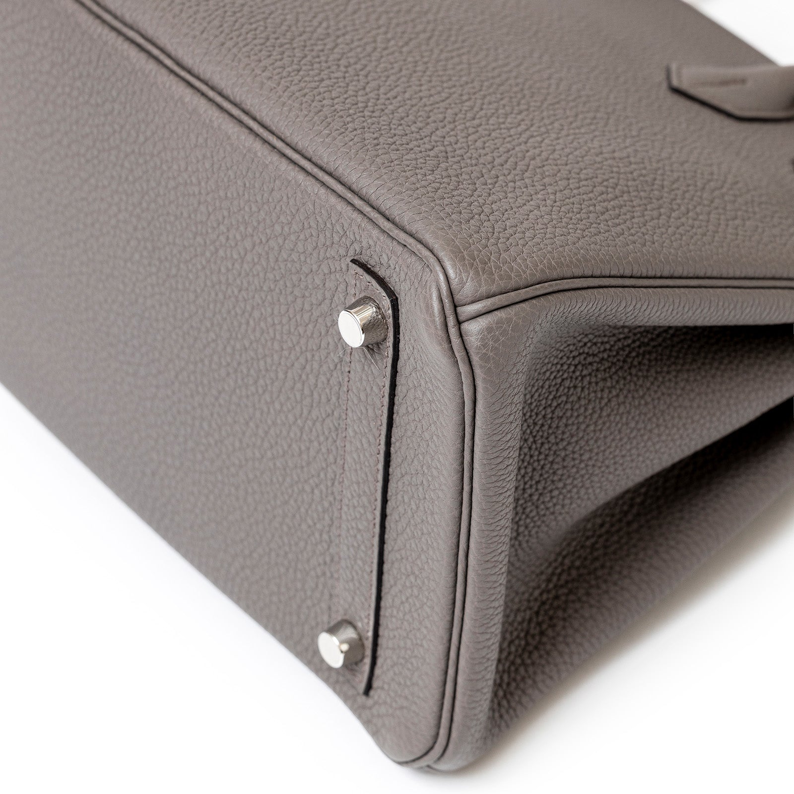 Close-up of bottom corner and palladium feet on Hermès Birkin 30 Etain Togo Palladium Hardware bag.