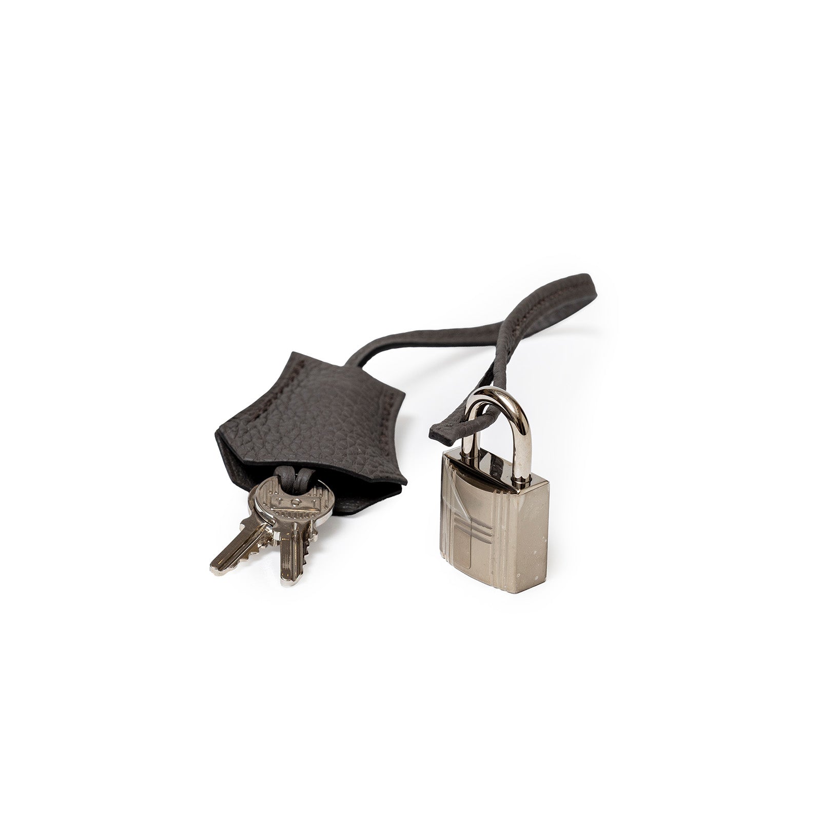 Close-up of Hermès Birkin 30 Etain Togo Palladium Hardware lock with keys and leather clochette on white background.