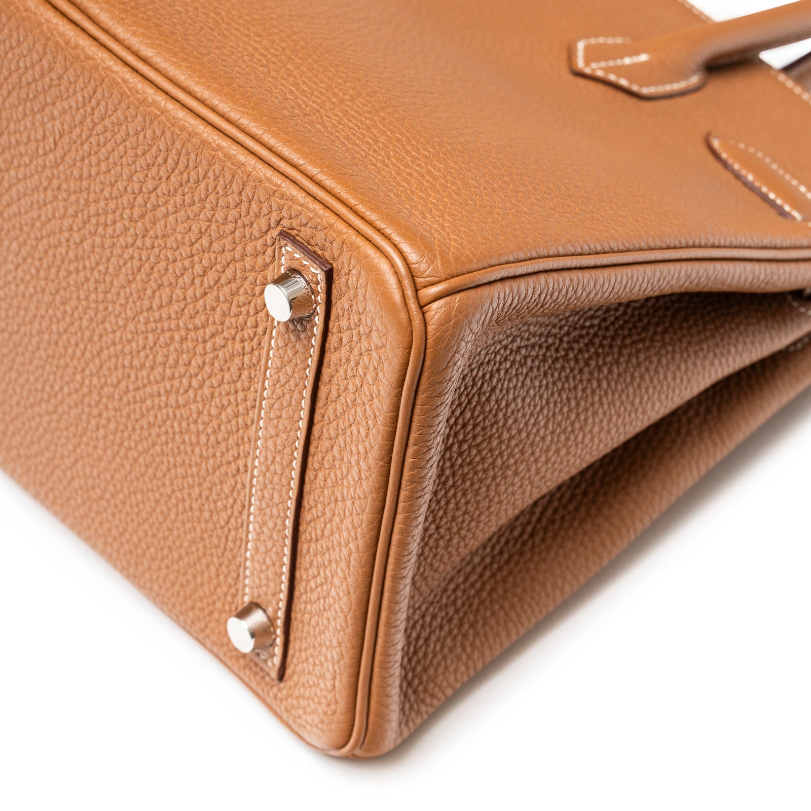 Close-up of the bottom corner and feet of Hermès Birkin 30 Gold Togo Palladium Hardware handbag showing leather texture and stitching detail
