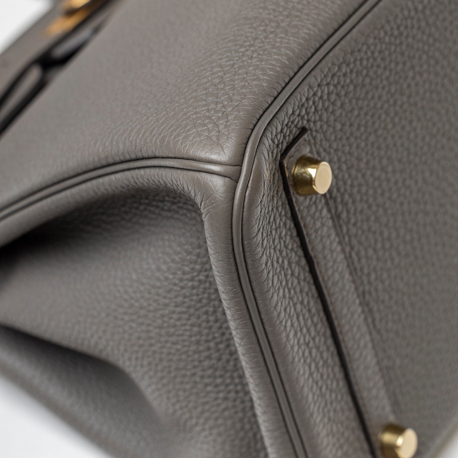 Close-up angled view of Hermès Birkin 30 Gris Meyer Togo Gold Hardware showing pebbled leather and gold feet