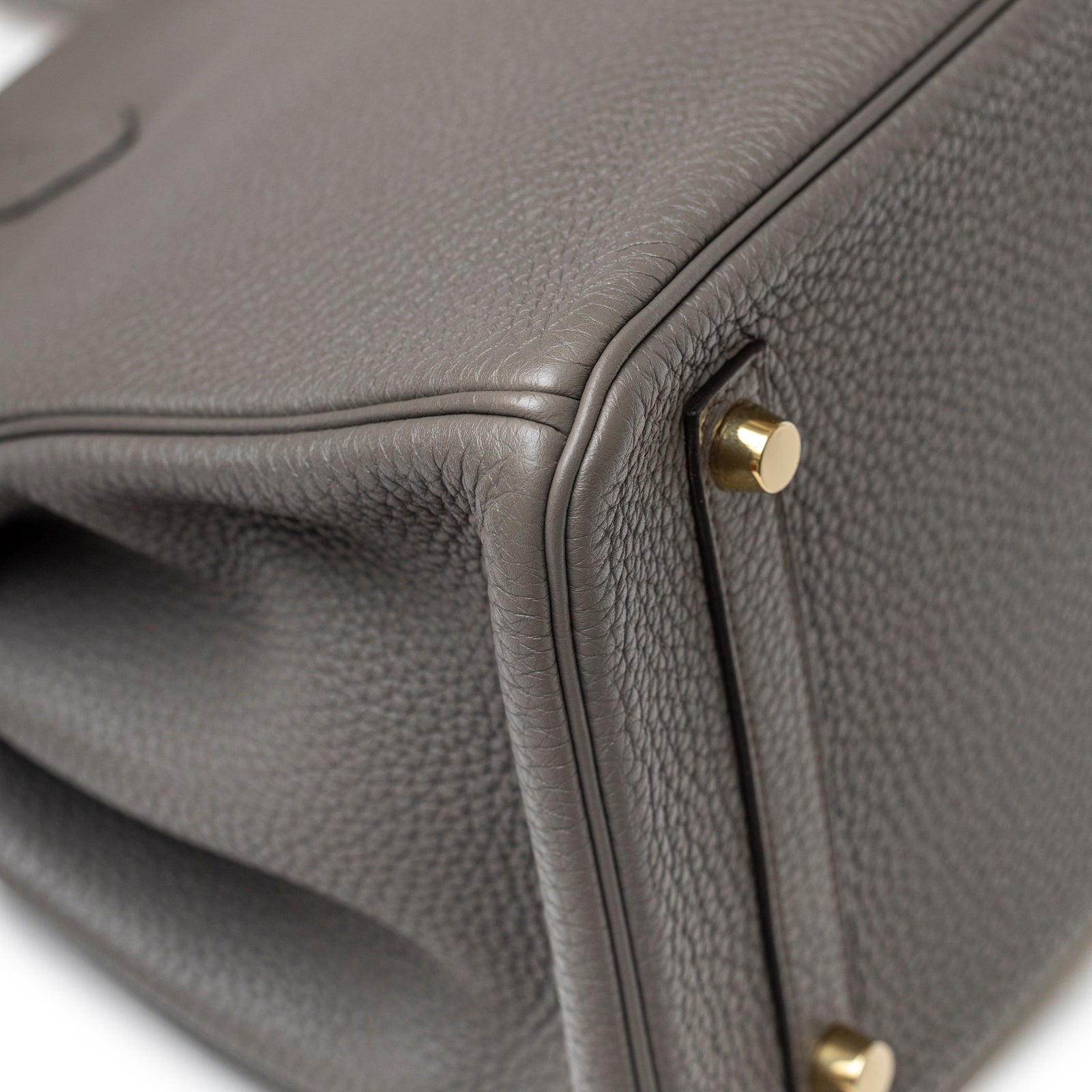 Close-up of bottom corner showing textured leather and gold hardware on Hermès Birkin 30 Gris Meyer Togo Gold Hardware