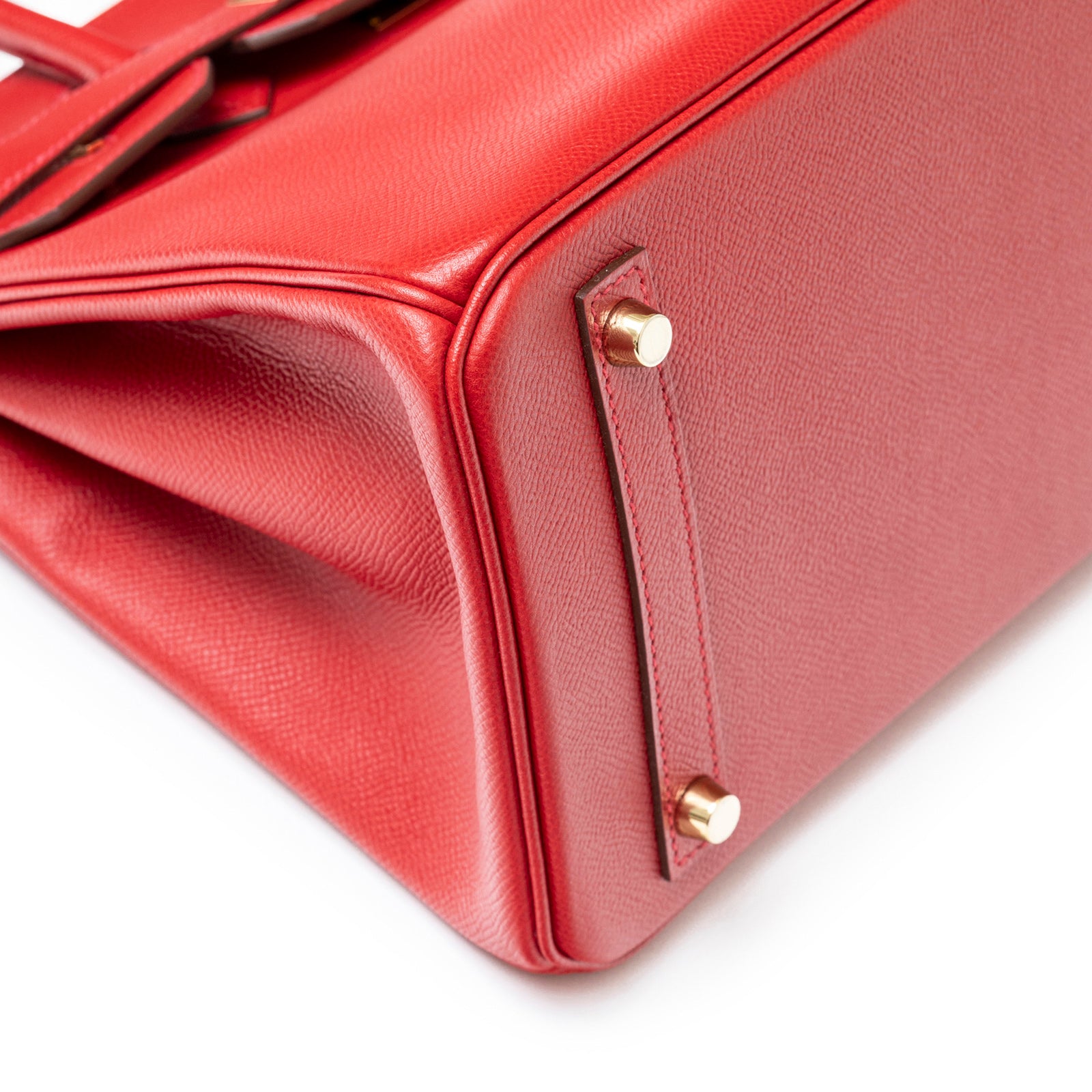 Close-up of bottom corner showing gold hardware and textured leather on Hermès Birkin 30 Rouge Casaque Epsom Gold Hardware