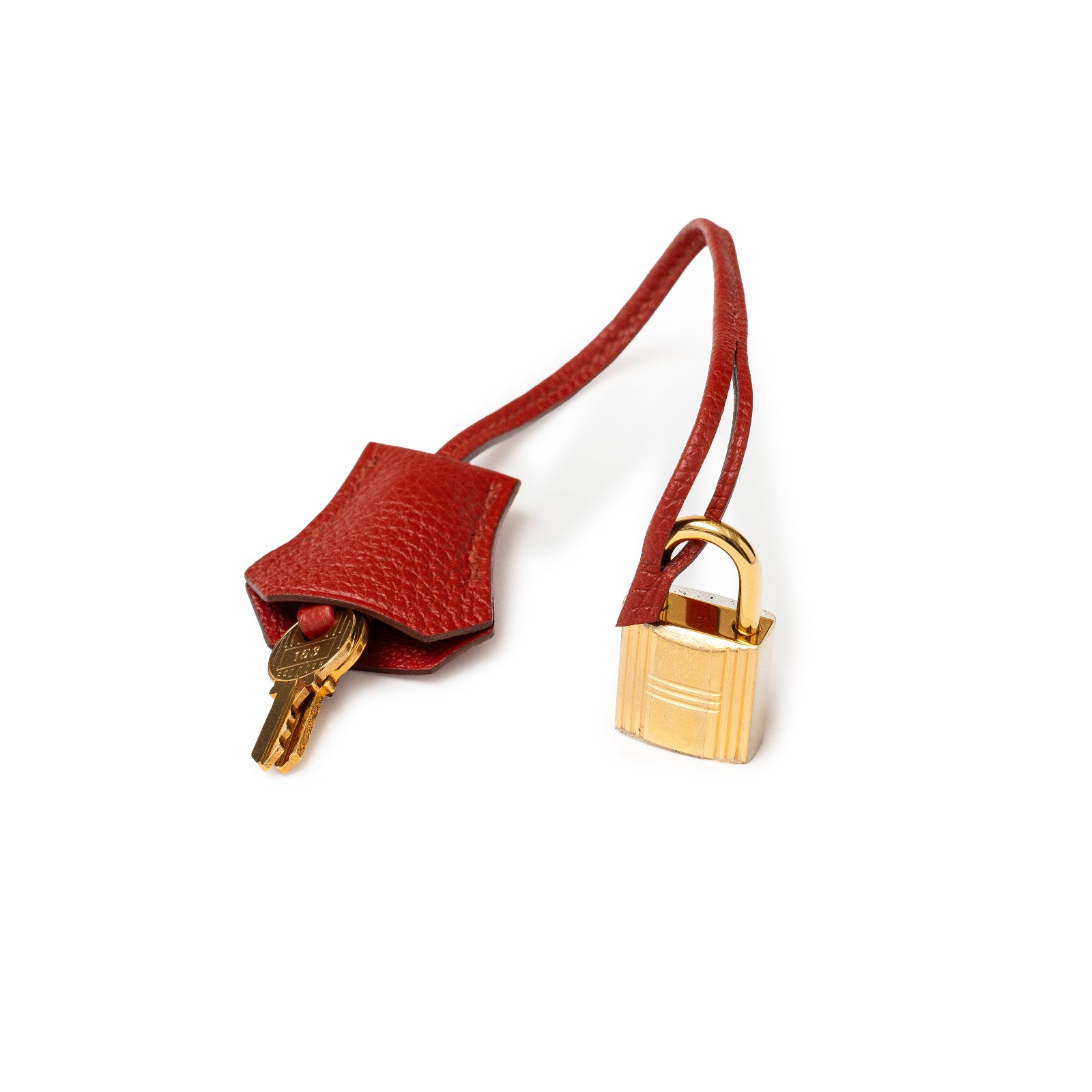 Close-up of Hermès Birkin 30 Rouge Togo Gold Hardware lock and key clochette with leather strap accessory.