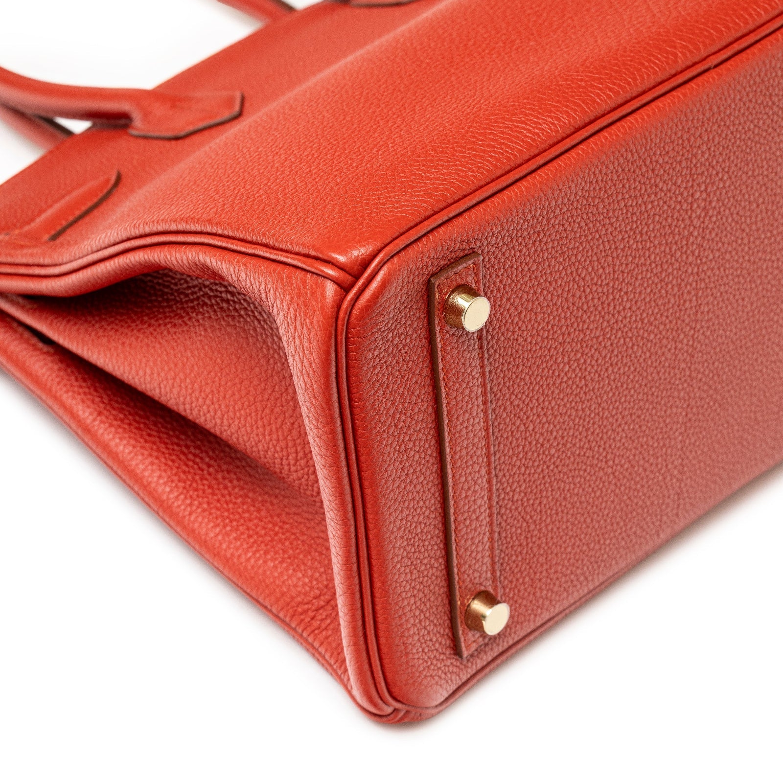 Close-up of bottom corner showing textured Rouge Togo leather and gold hardware on Hermès Birkin 30 Rouge Togo Gold Hardware