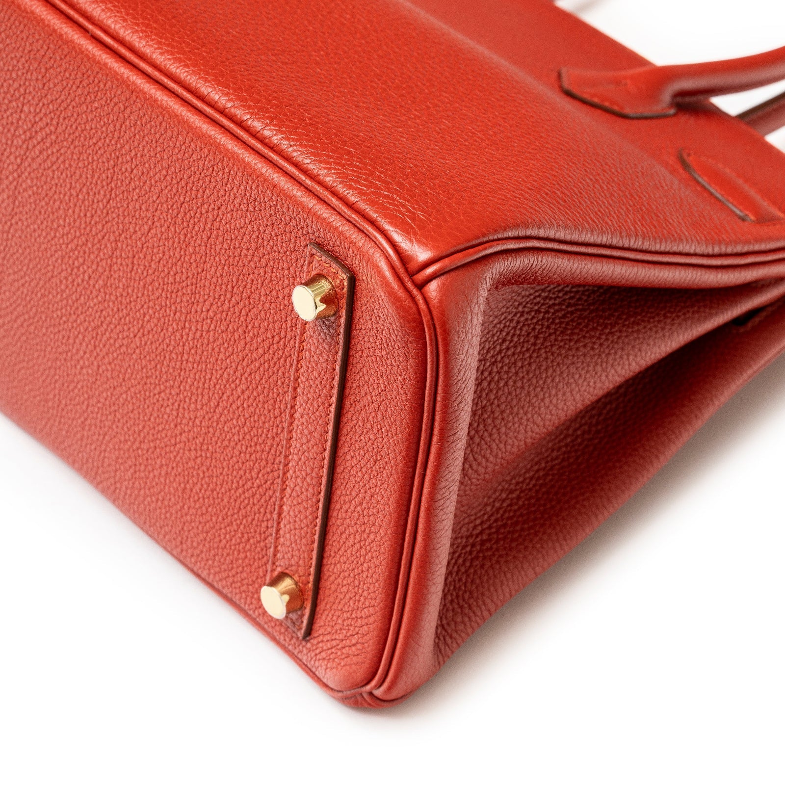 Close-up of base and gold hardware feet on Hermès Birkin 30 Rouge Togo Gold Hardware handbag.