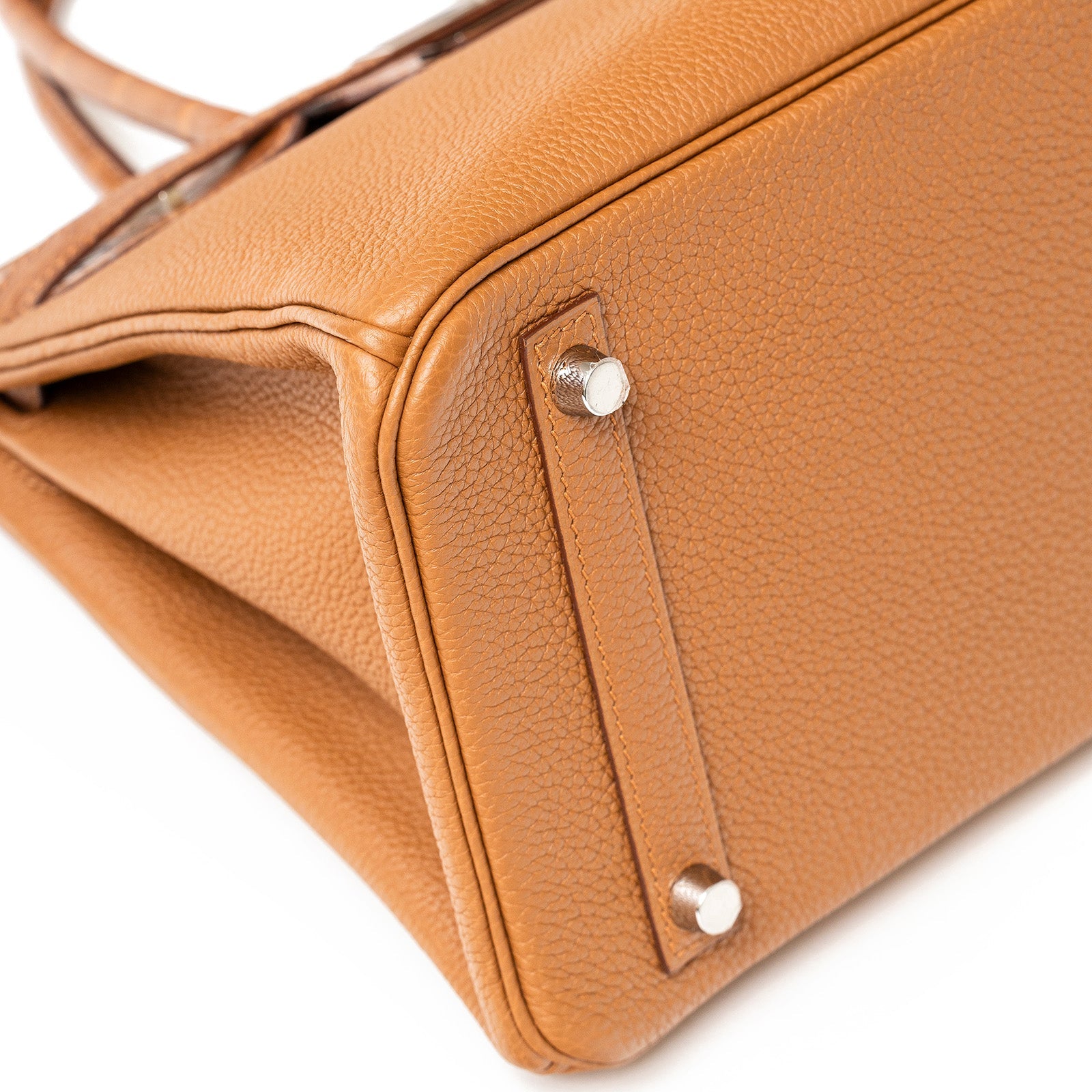 Close-up angled view of the Hermès Birkin 30 in gold togo leather showing the bag’s base and hardware feet