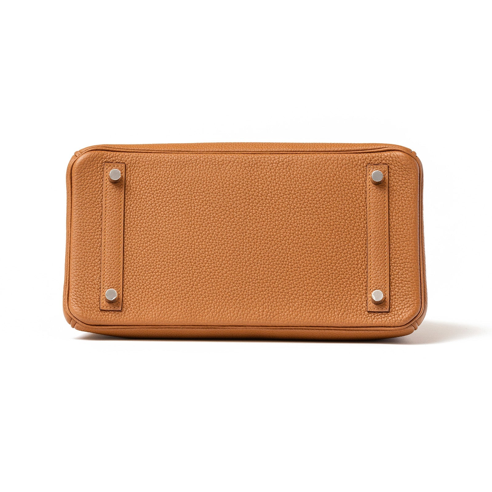 Bottom view of Hermès Birkin 30 in tan togo leather showing four protective metal feet on white background