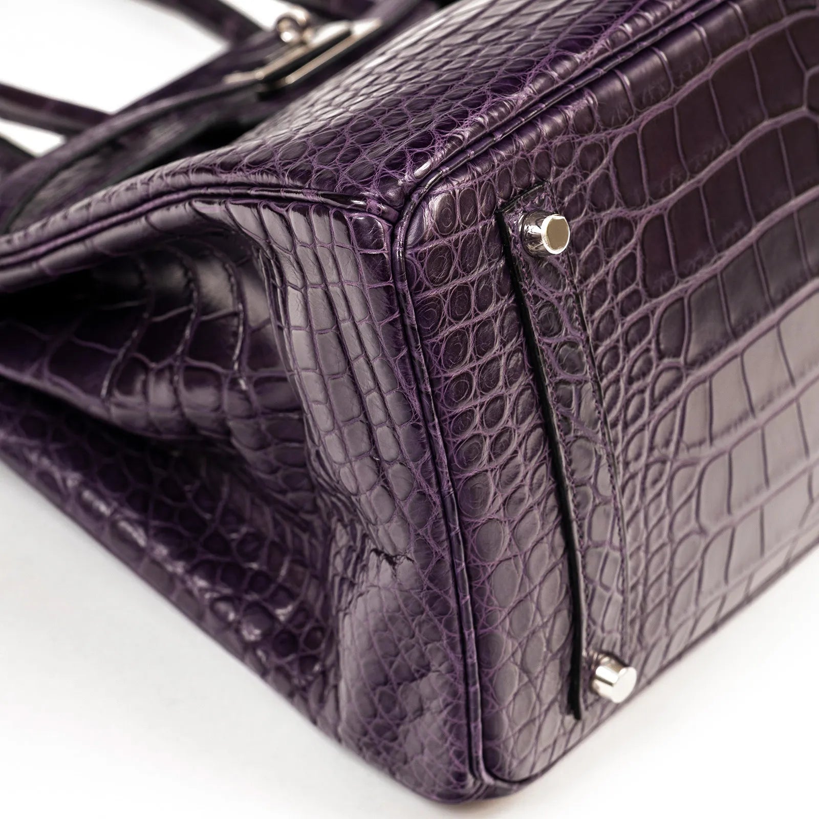 Close-up angled shot of Hermès Birkin 35 Amethyste Matte Alligator with palladium hardware corner details.