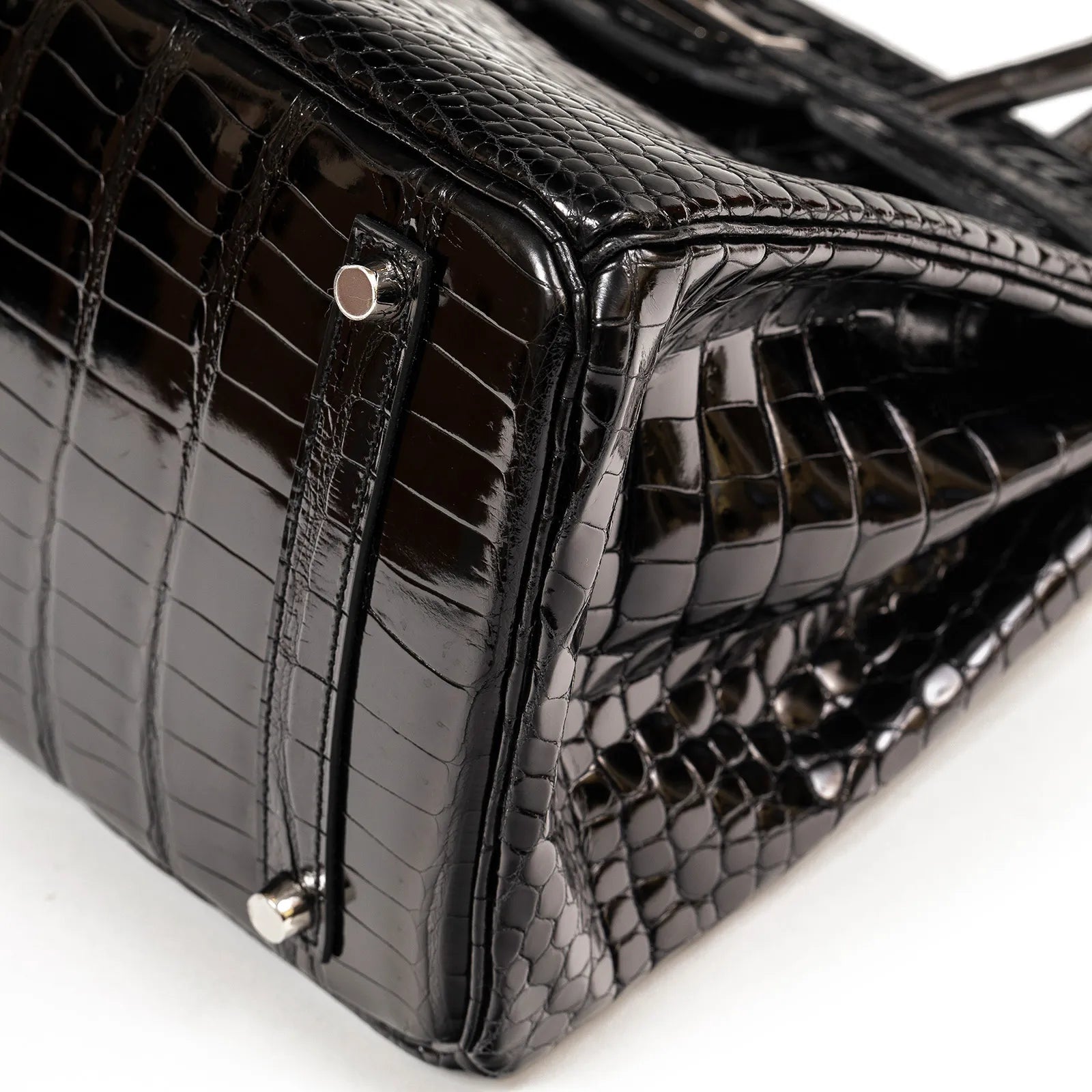 Close-up of base and side of Hermès Birkin 35 Black Shiny Porosus with Palladium Hardware showing texture and stitching detail