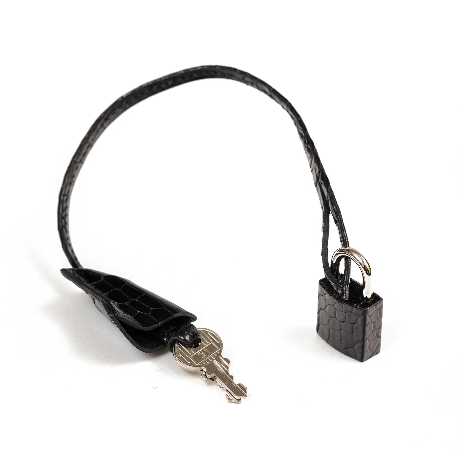 Close-up of Hermès Birkin 35 Black Shiny Porosus lock and key with palladium hardware detail.