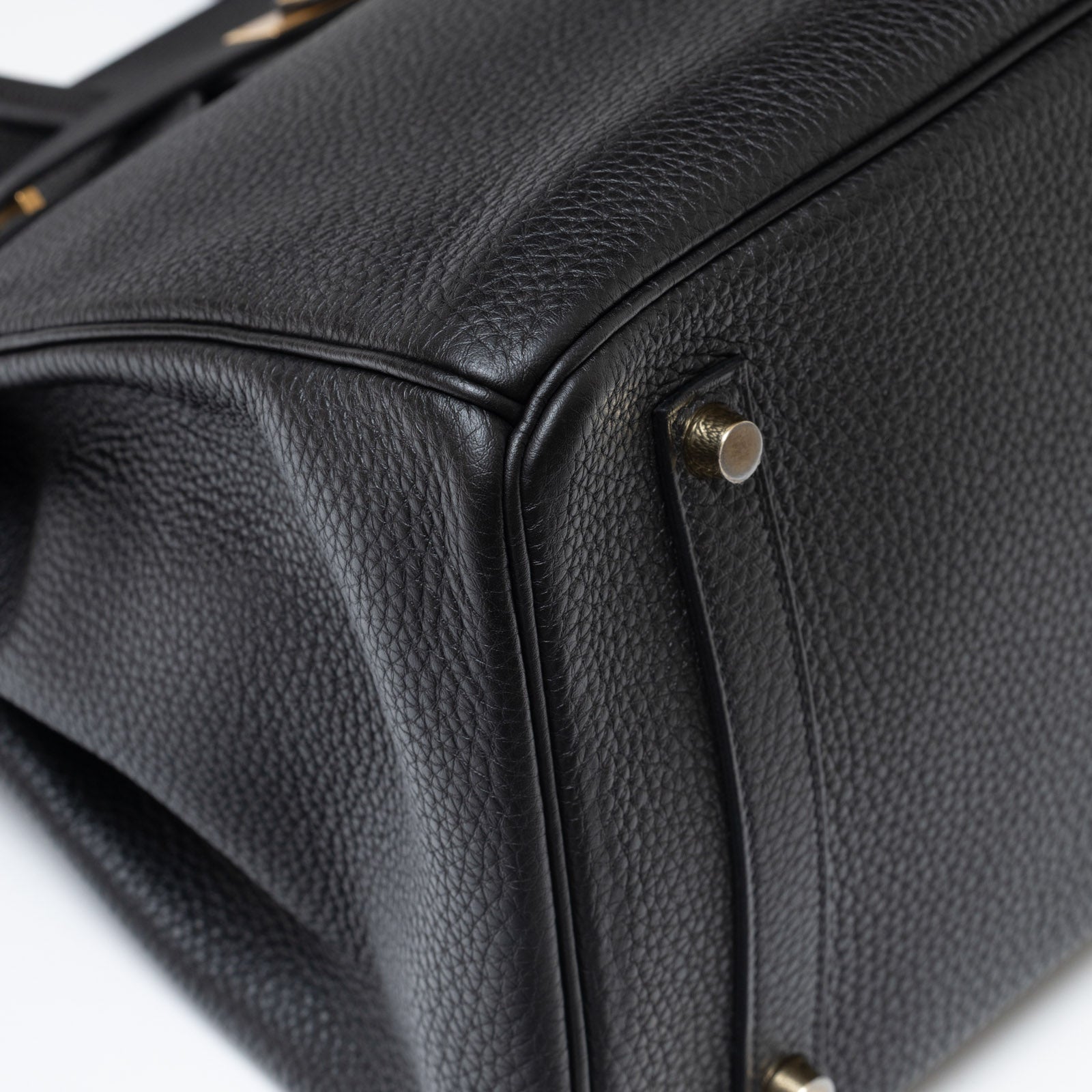 Close-up of bottom corner showing black Togo leather texture and gold hardware on Hermès Birkin 35 Black Togo Gold Hardware