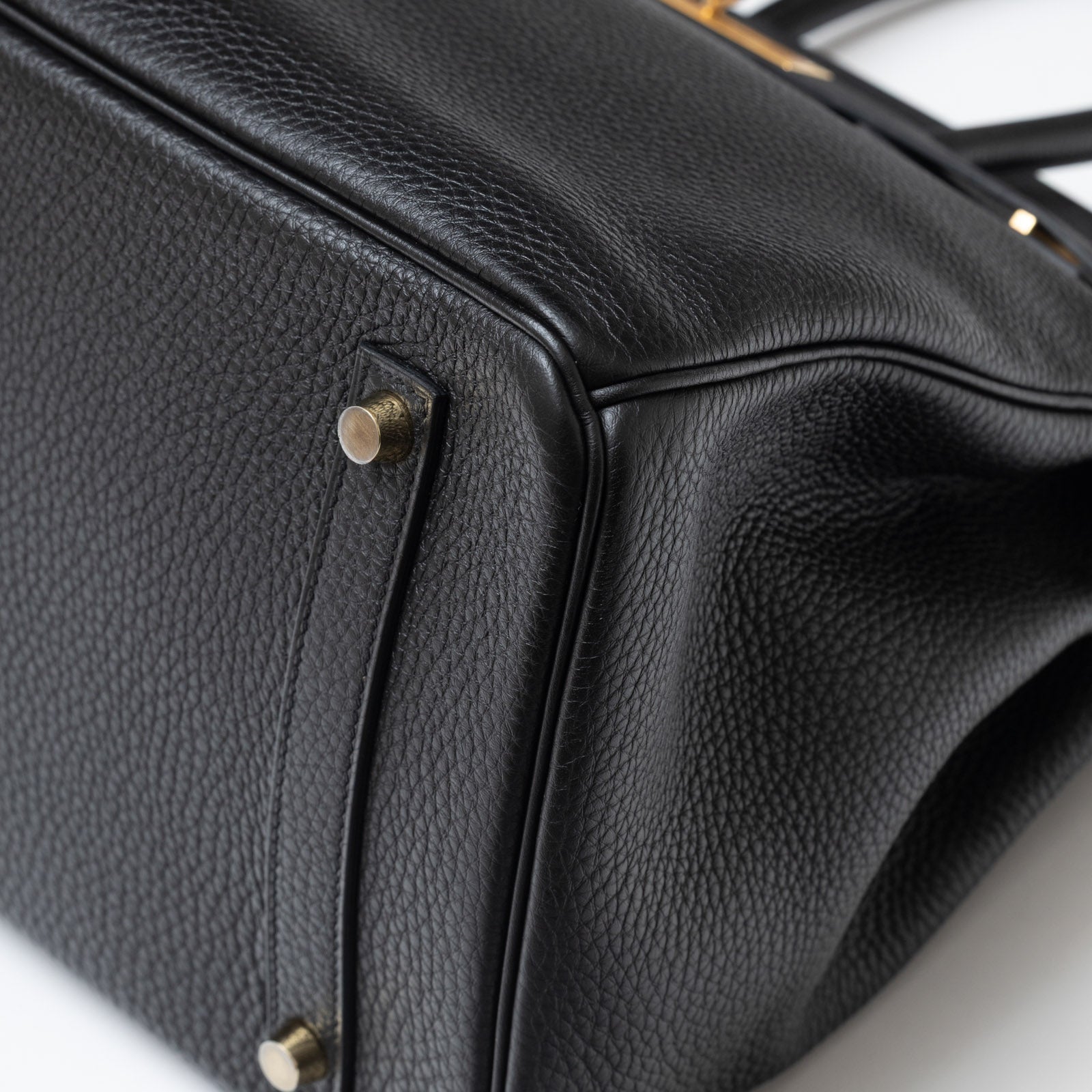Close-up of bottom corner showing black Togo leather texture and gold hardware on Hermès Birkin 35 Black Togo Gold Hardware